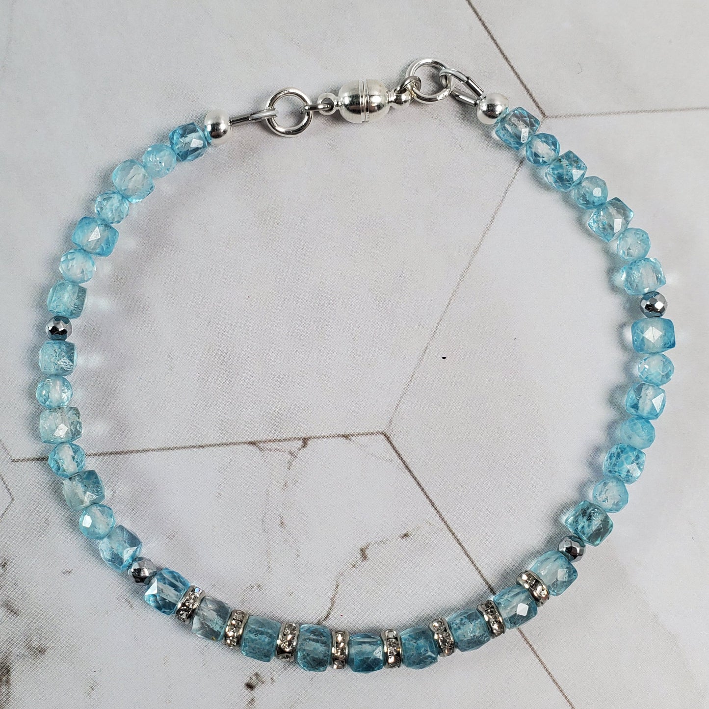 Beaded bracelet with blue beads on a marble surface
