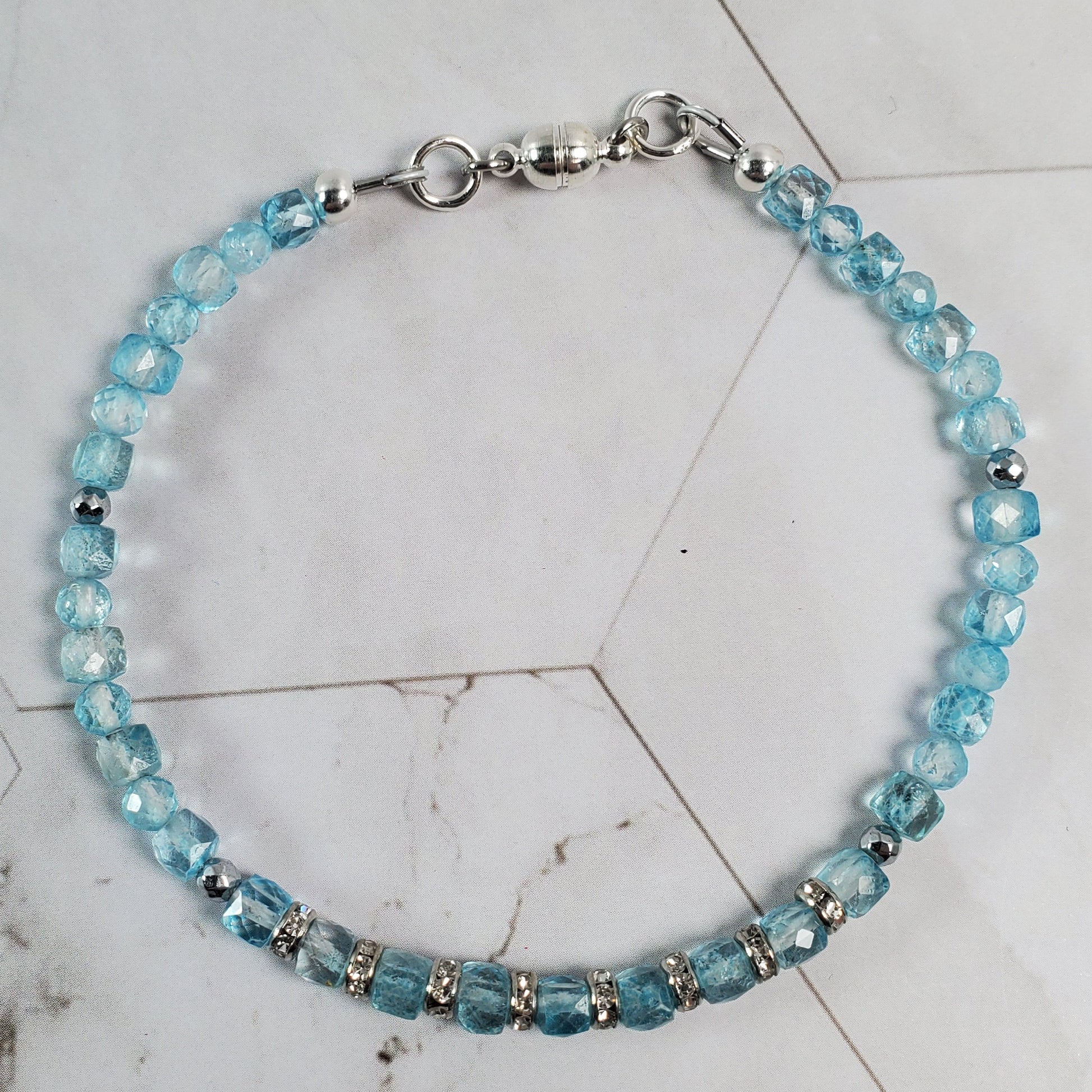 Beaded bracelet with blue beads on a marble surface