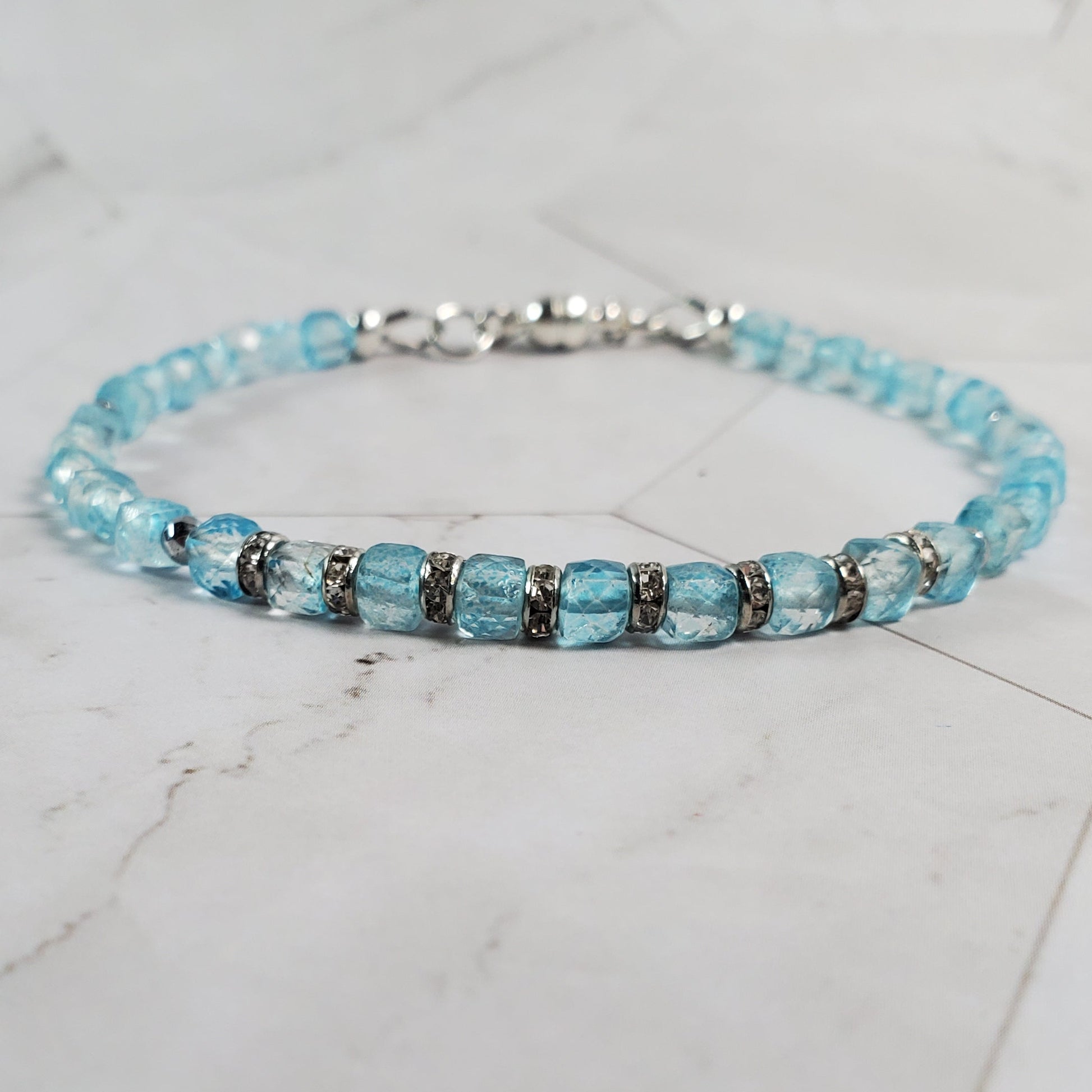 Beaded bracelet with blue and silver beads on a marble surface