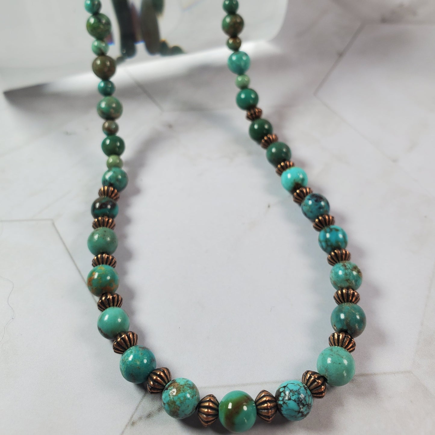 Necklace with turquoise and brown beads on a white background