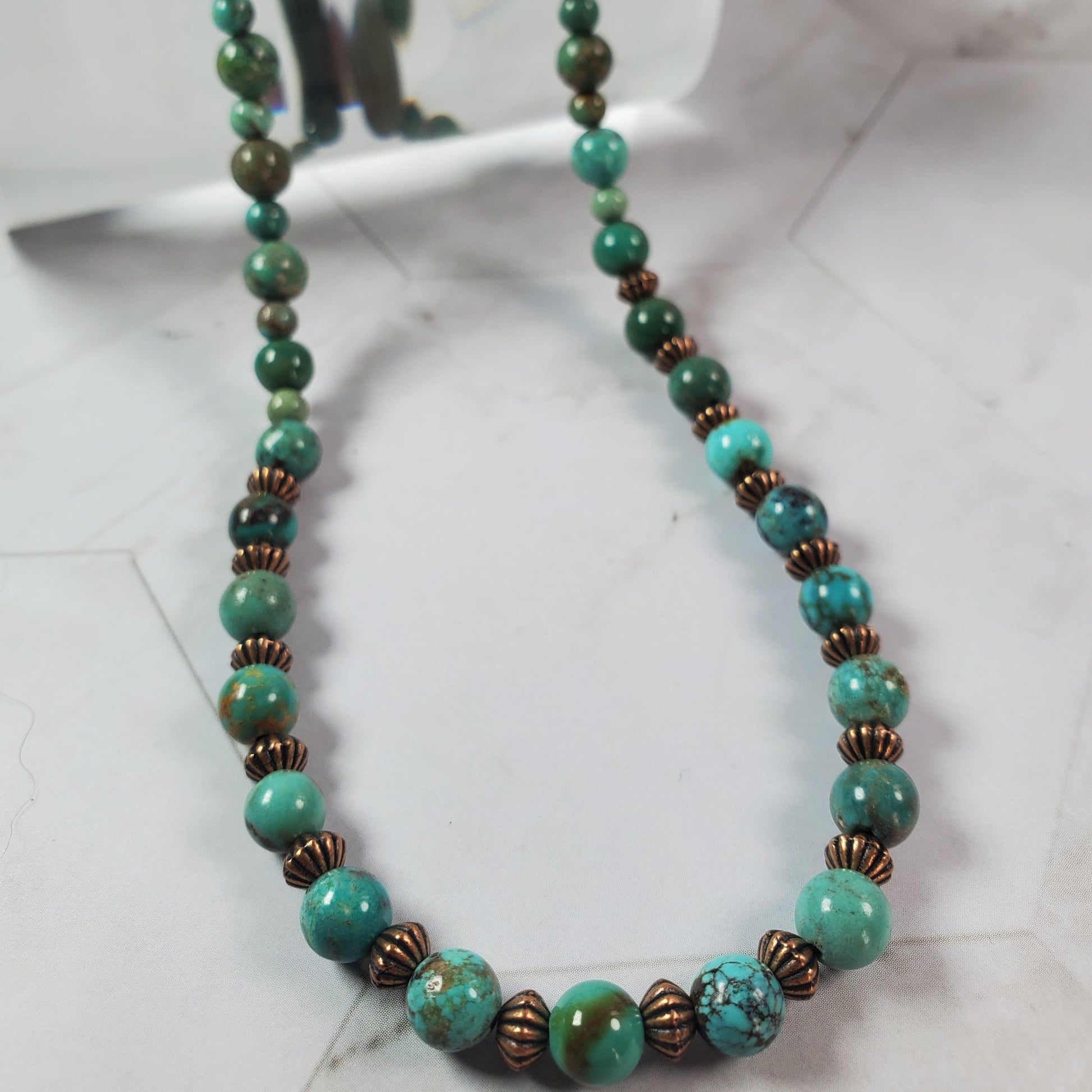 Necklace with turquoise and brown beads on a white background