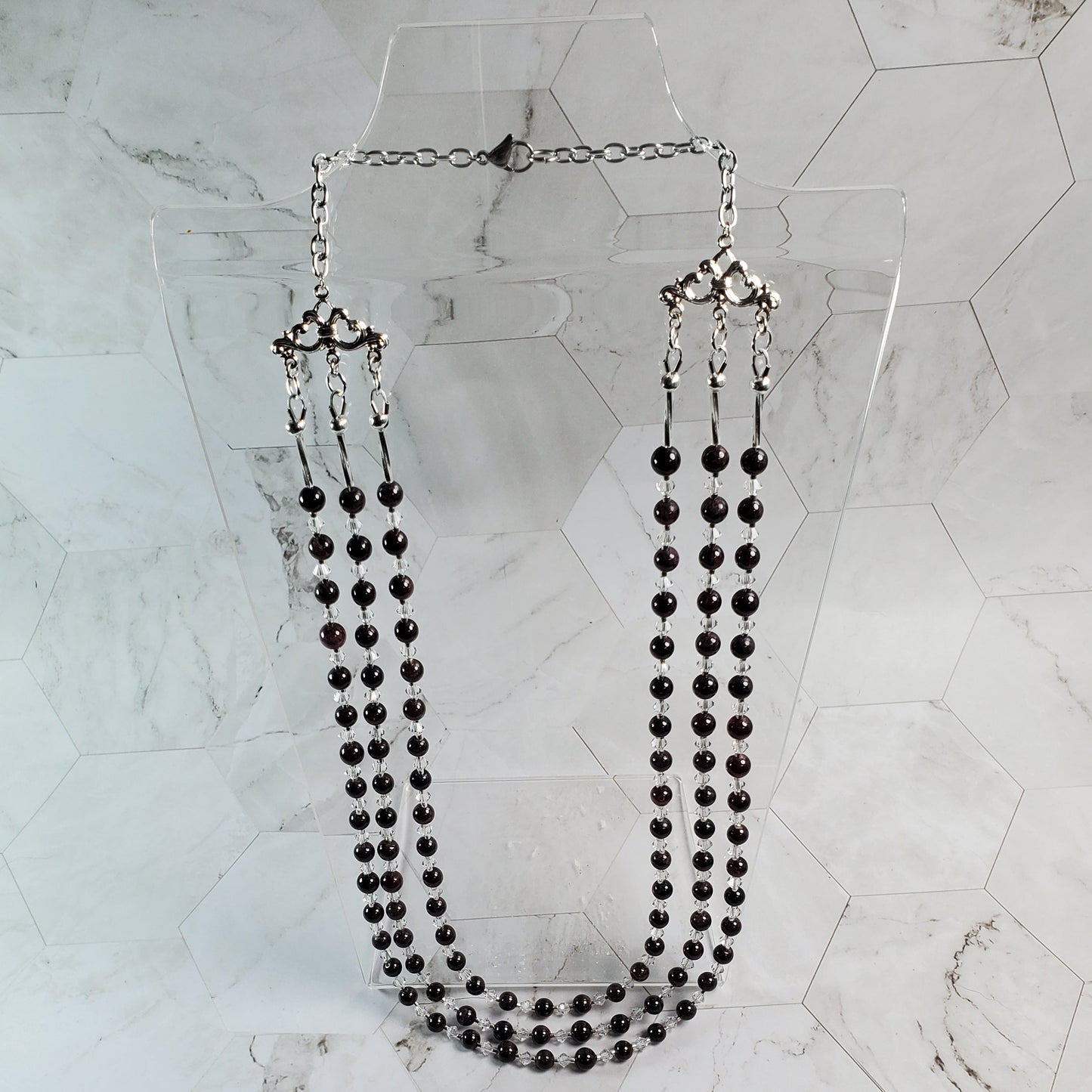 Red beaded necklace on a marble surface