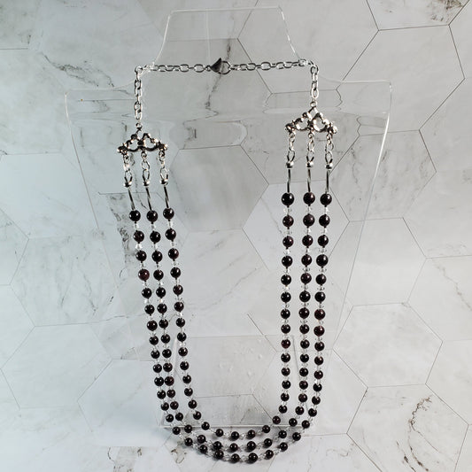 Red beaded necklace on a marble surface