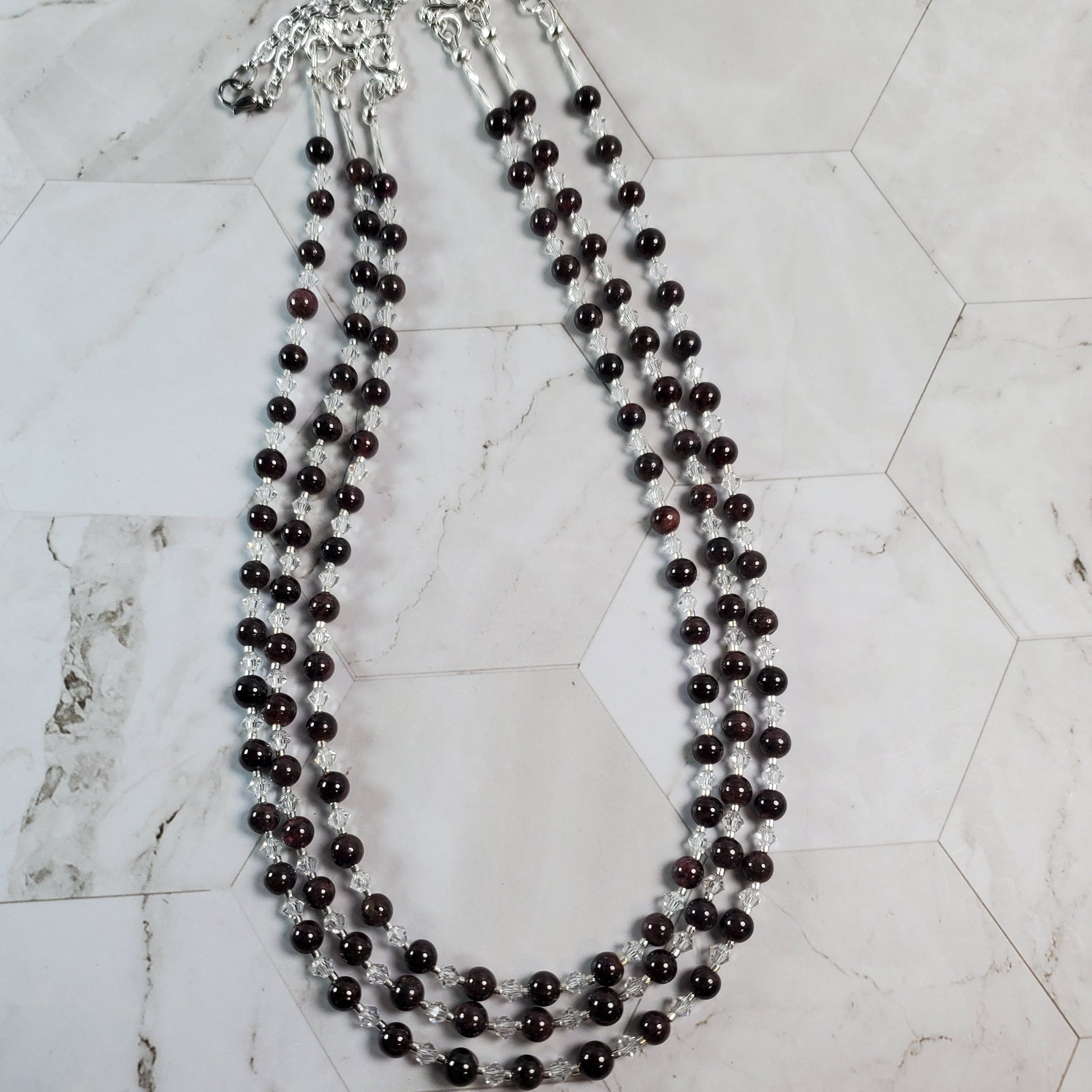 Long necklace with Garnet beads on a marble surface