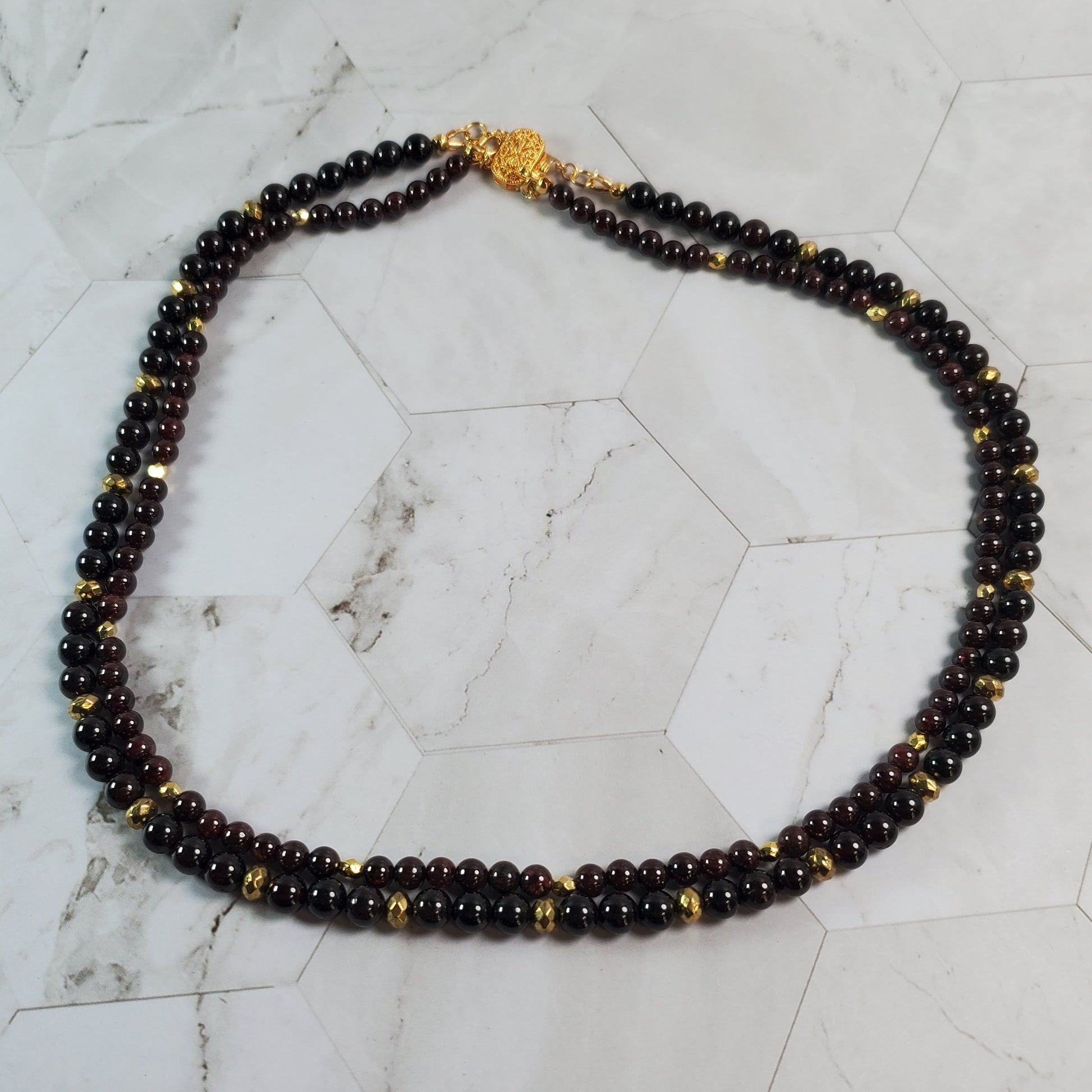 Beaded necklace with gold accents on a marble surface