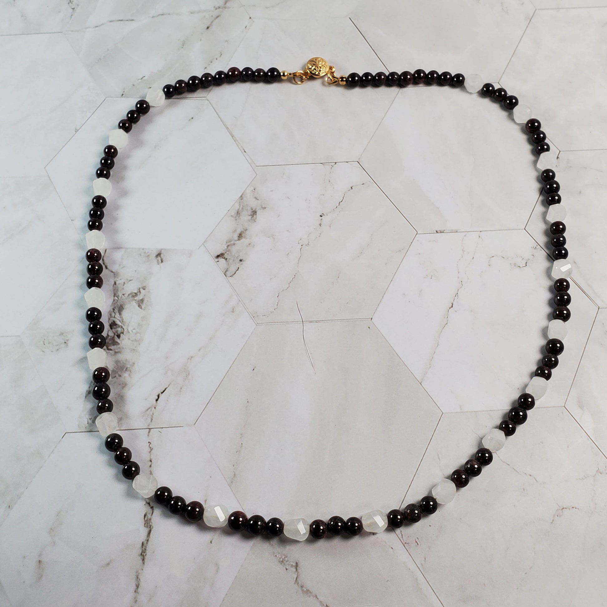 Garnet beaded necklace on a marble surface