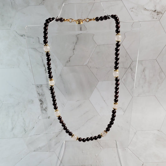 Necklace with Garnet and gold beads on a marble surface