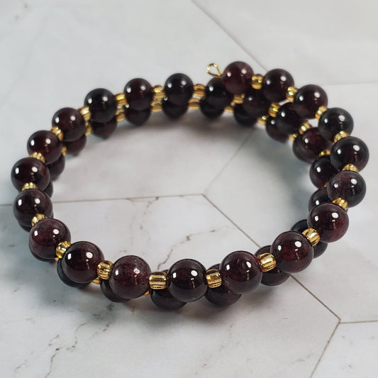 Beaded bracelet with gold accents on a marble surface