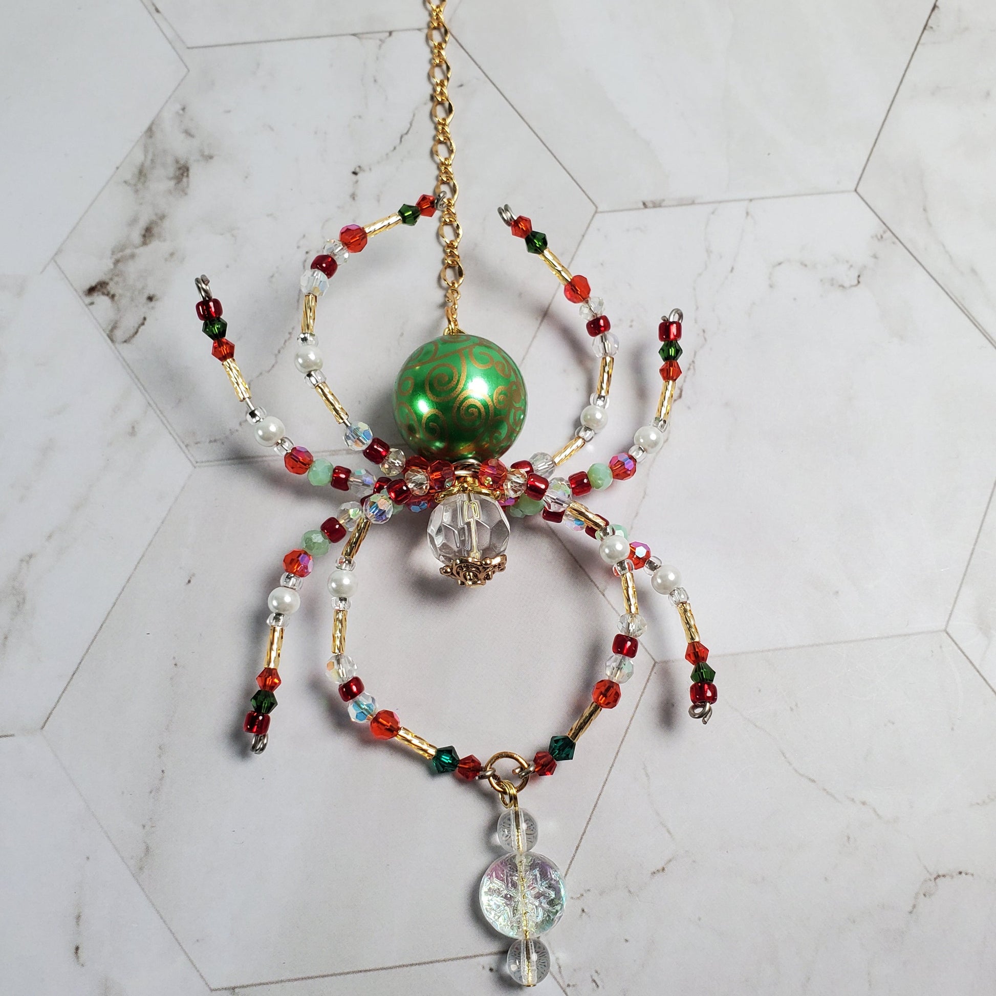 Decorative spider ornament with beads on a marble floor