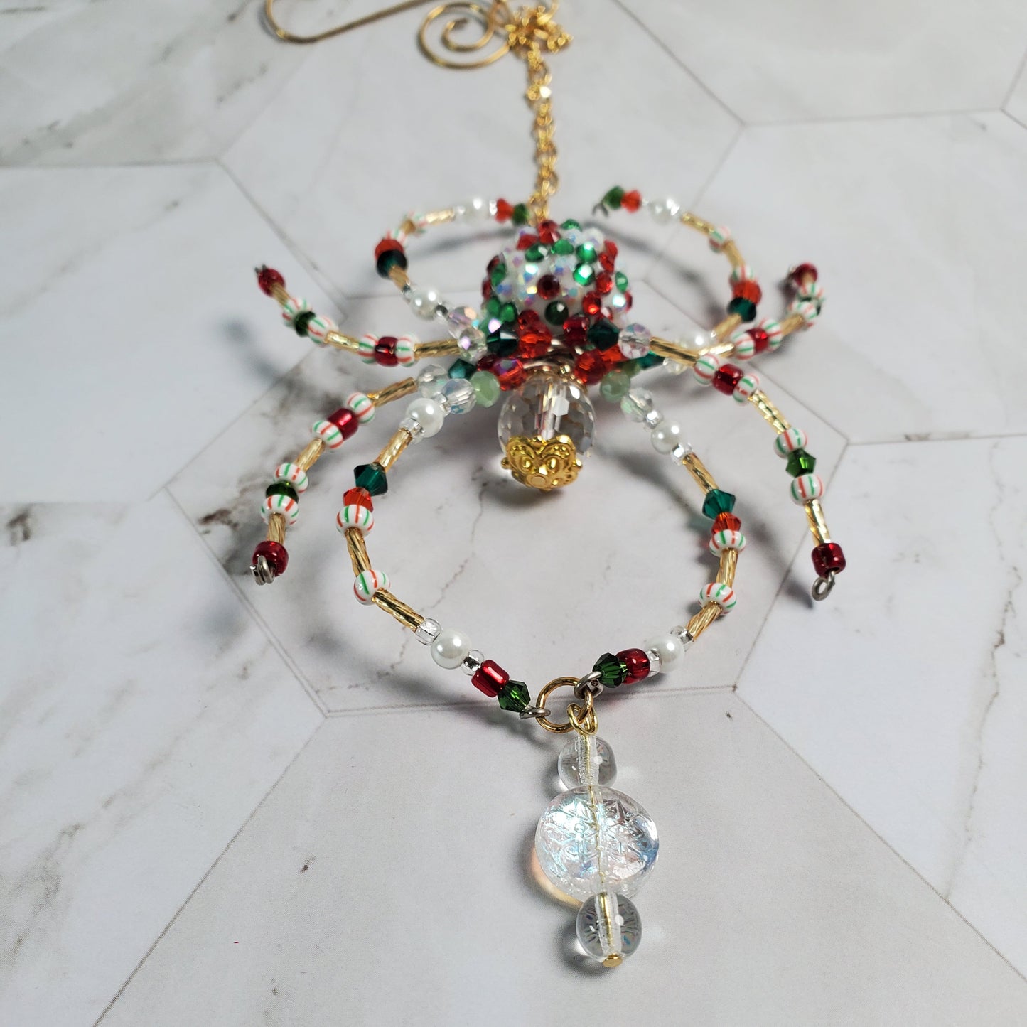 Decorative beaded spider ornament on a marble surface