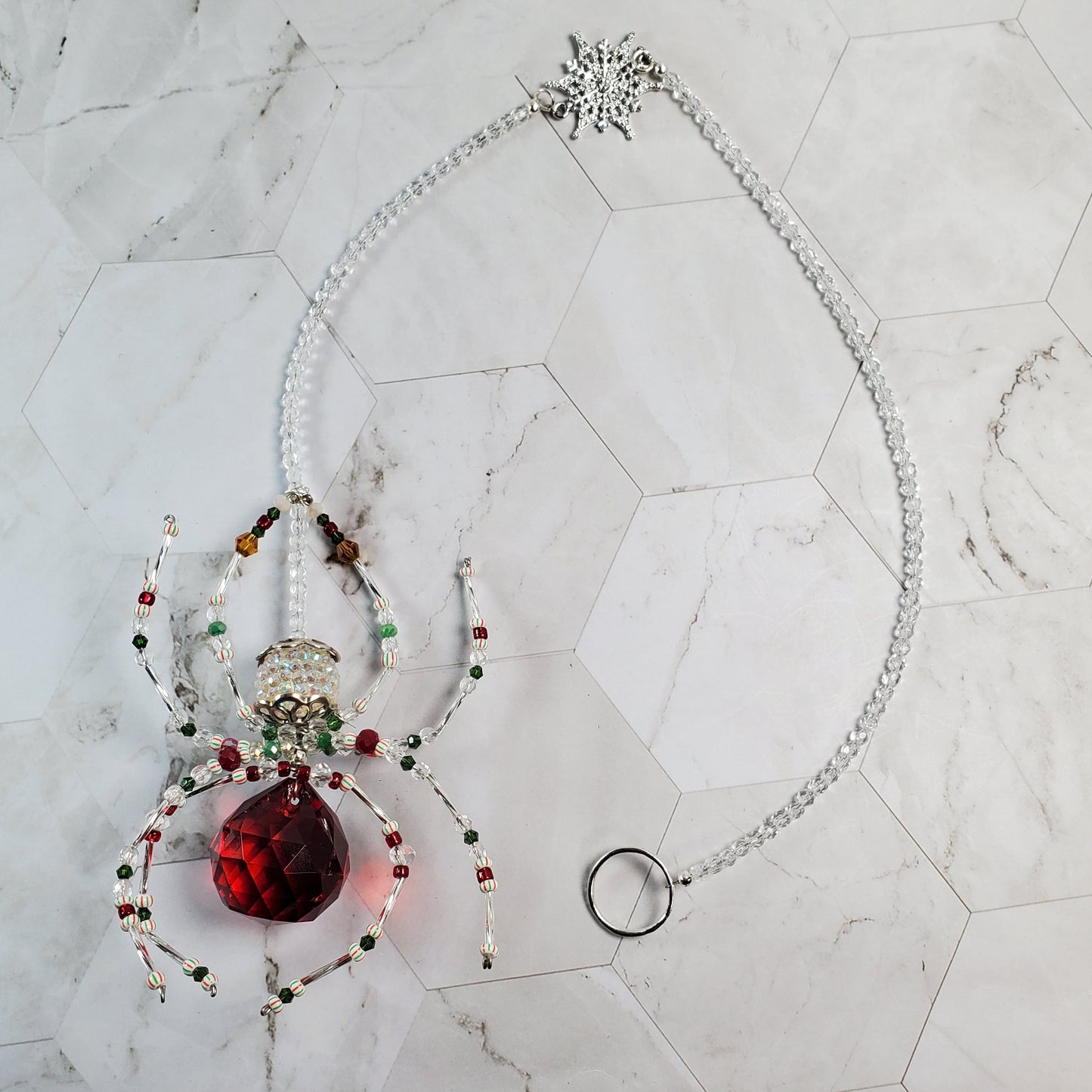 Decorative ornament with a red crystal on a marble surface