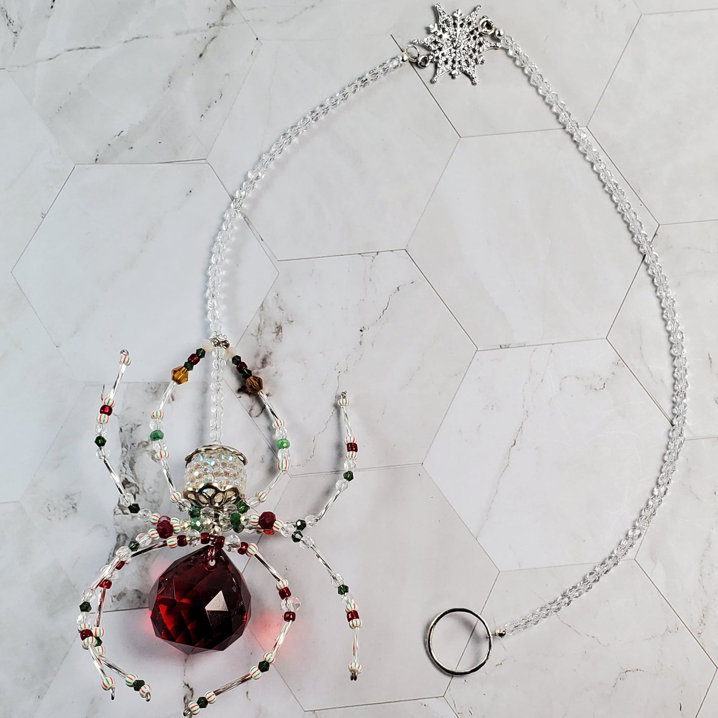 Crystal ornament with a red crystal on a marble surface