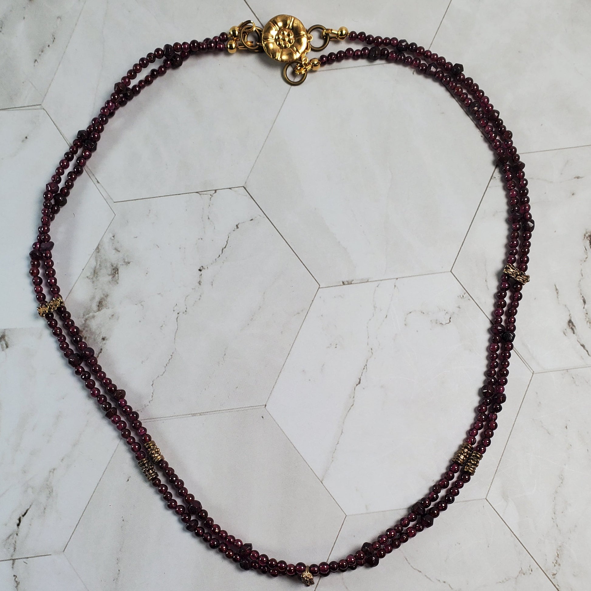 Beaded necklace with a gold clasp on a marble surface