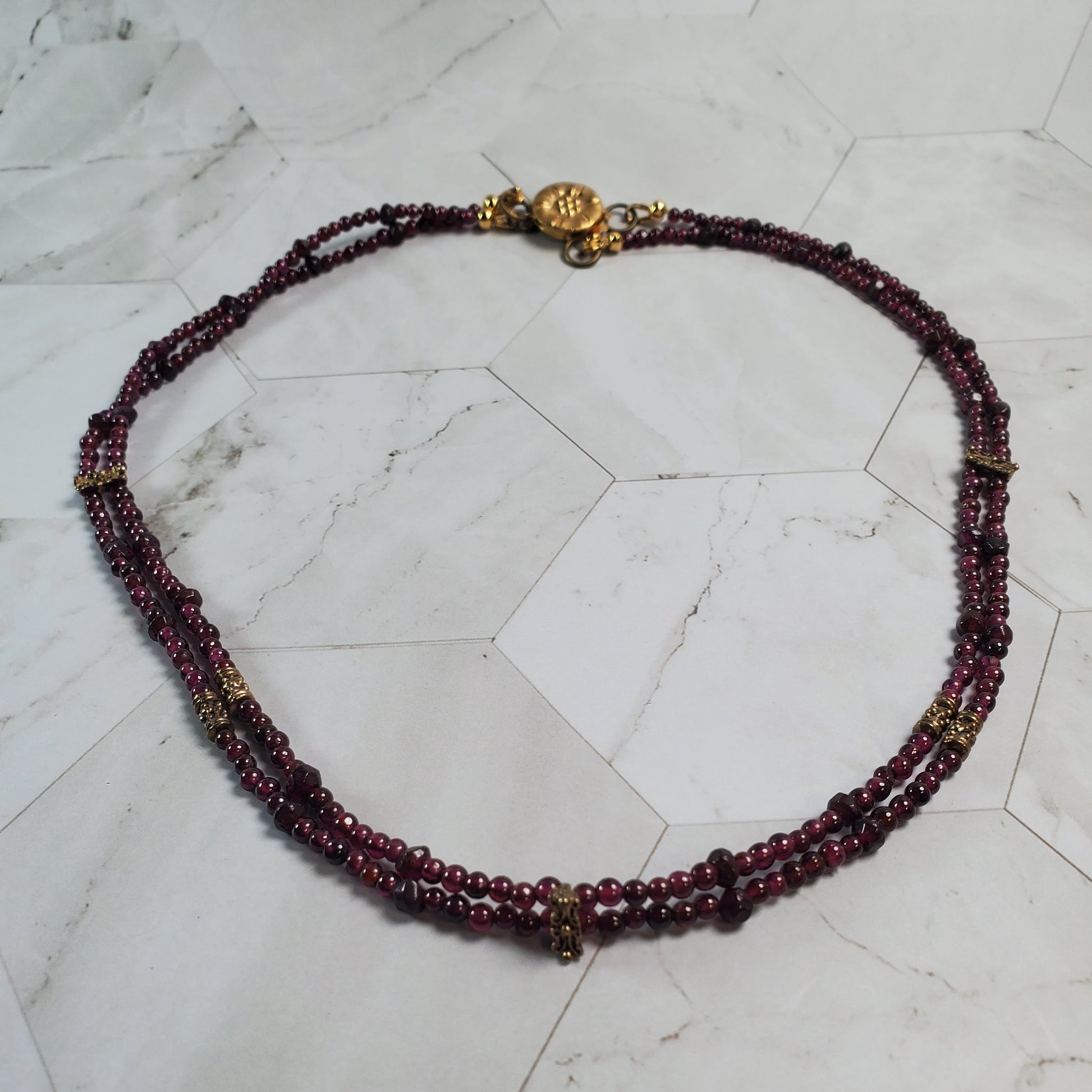 Beaded necklace with gold accents on a marble surface