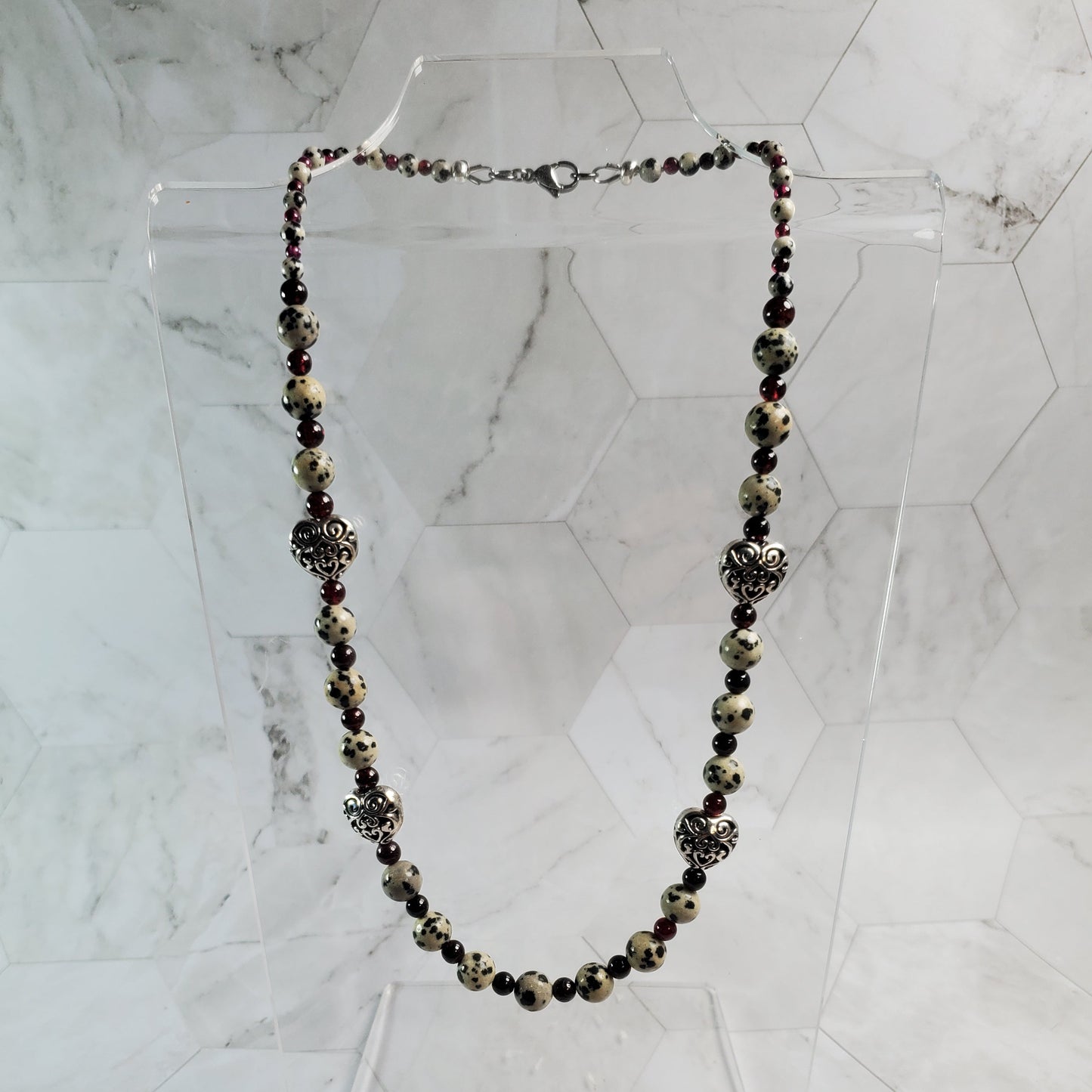 Necklace with beads and floral elements on a marble background