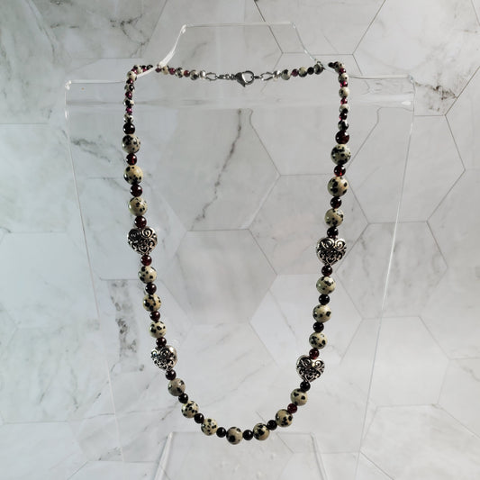 Necklace with beads and floral elements on a marble background