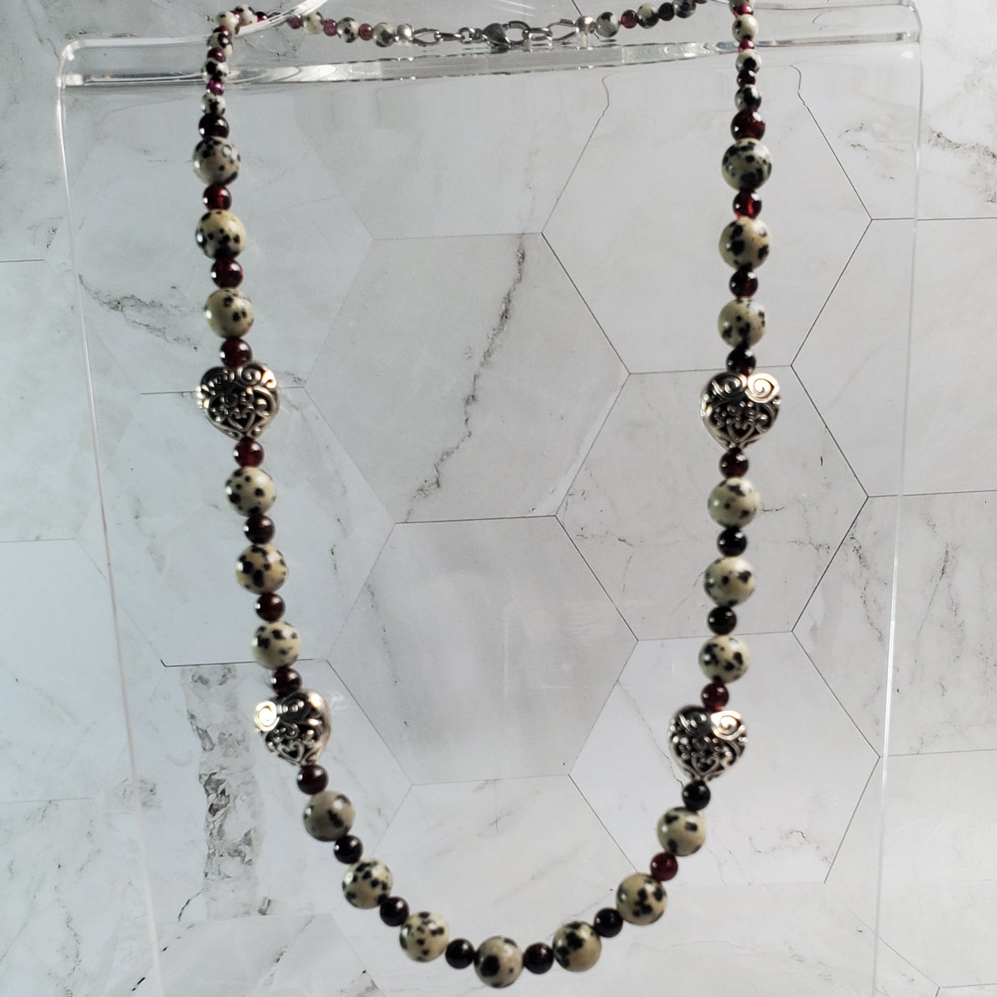 Necklace with black and gold stones on a marble background
