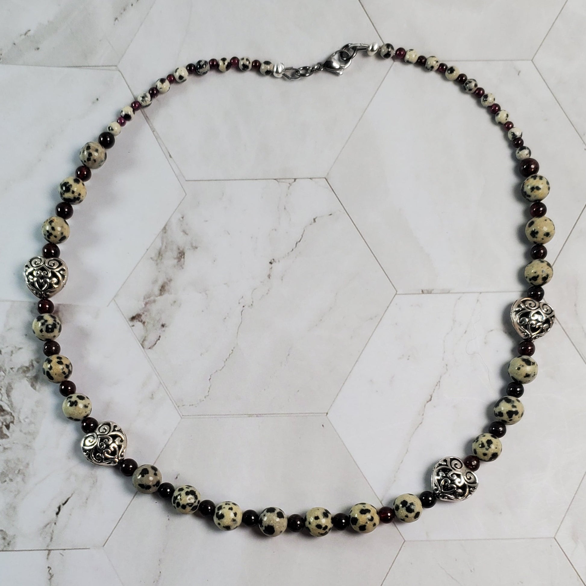 Necklace with black and gold beads on a marble surface