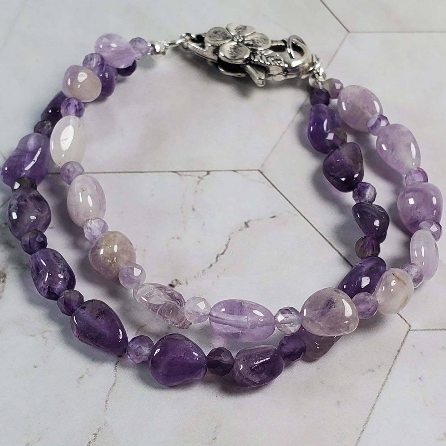 Purple beaded bracelet on a marble surface