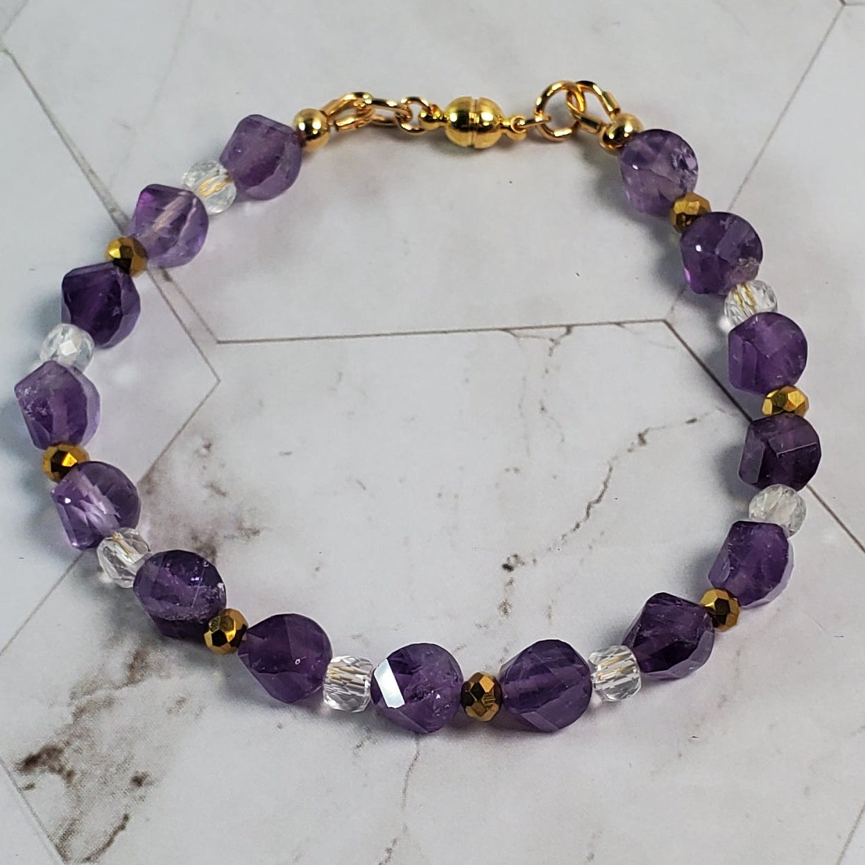 Purple beaded bracelet on a marble surface