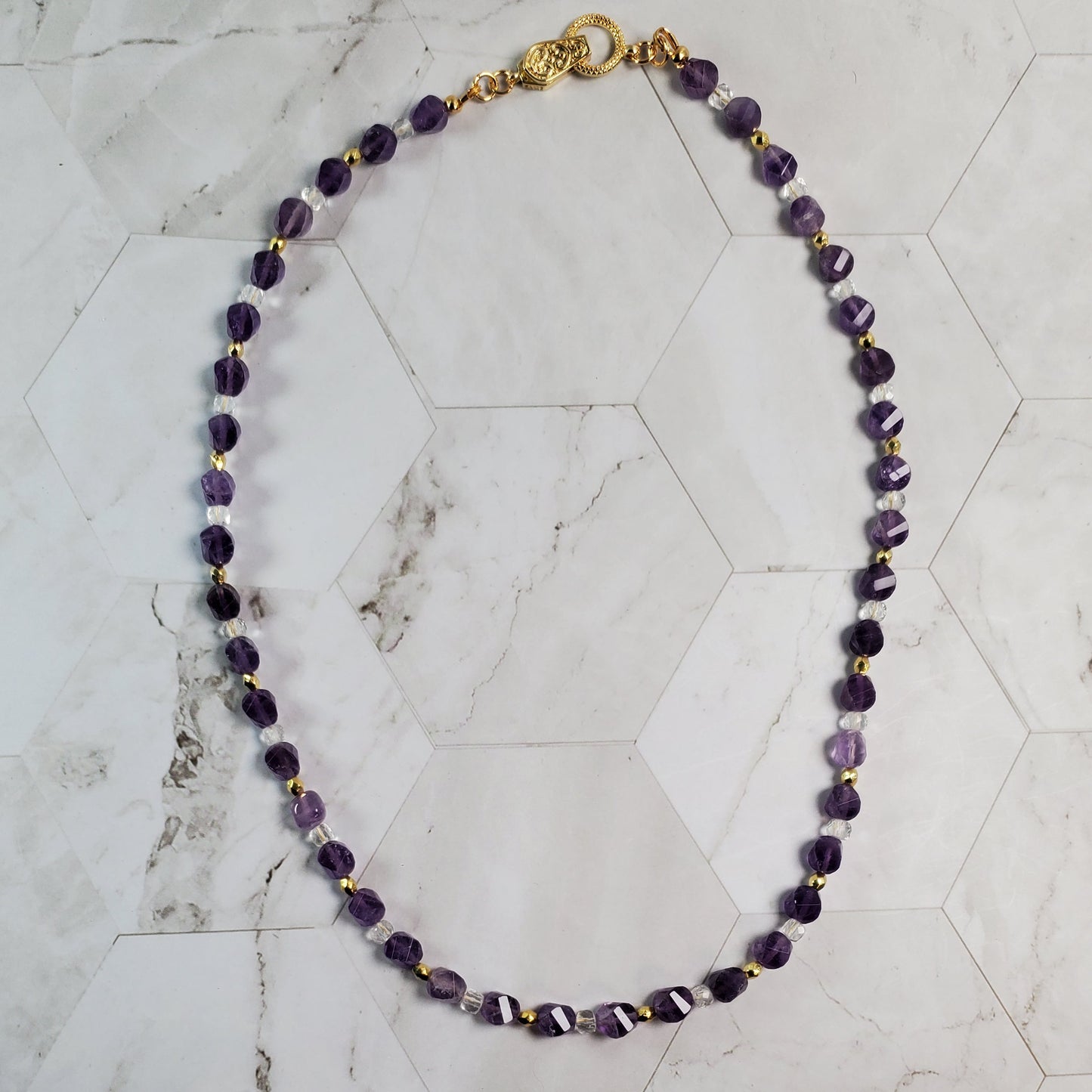 Purple beaded necklace on a marble surface