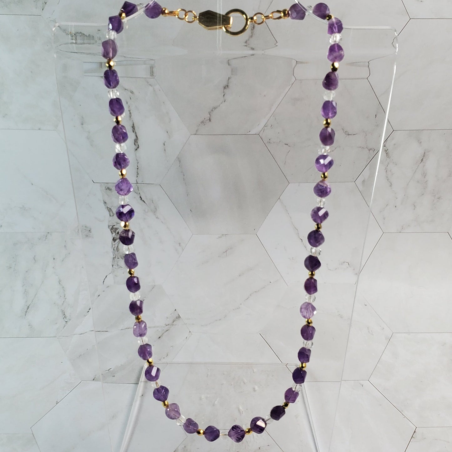 Purple beaded necklace on a marble surface