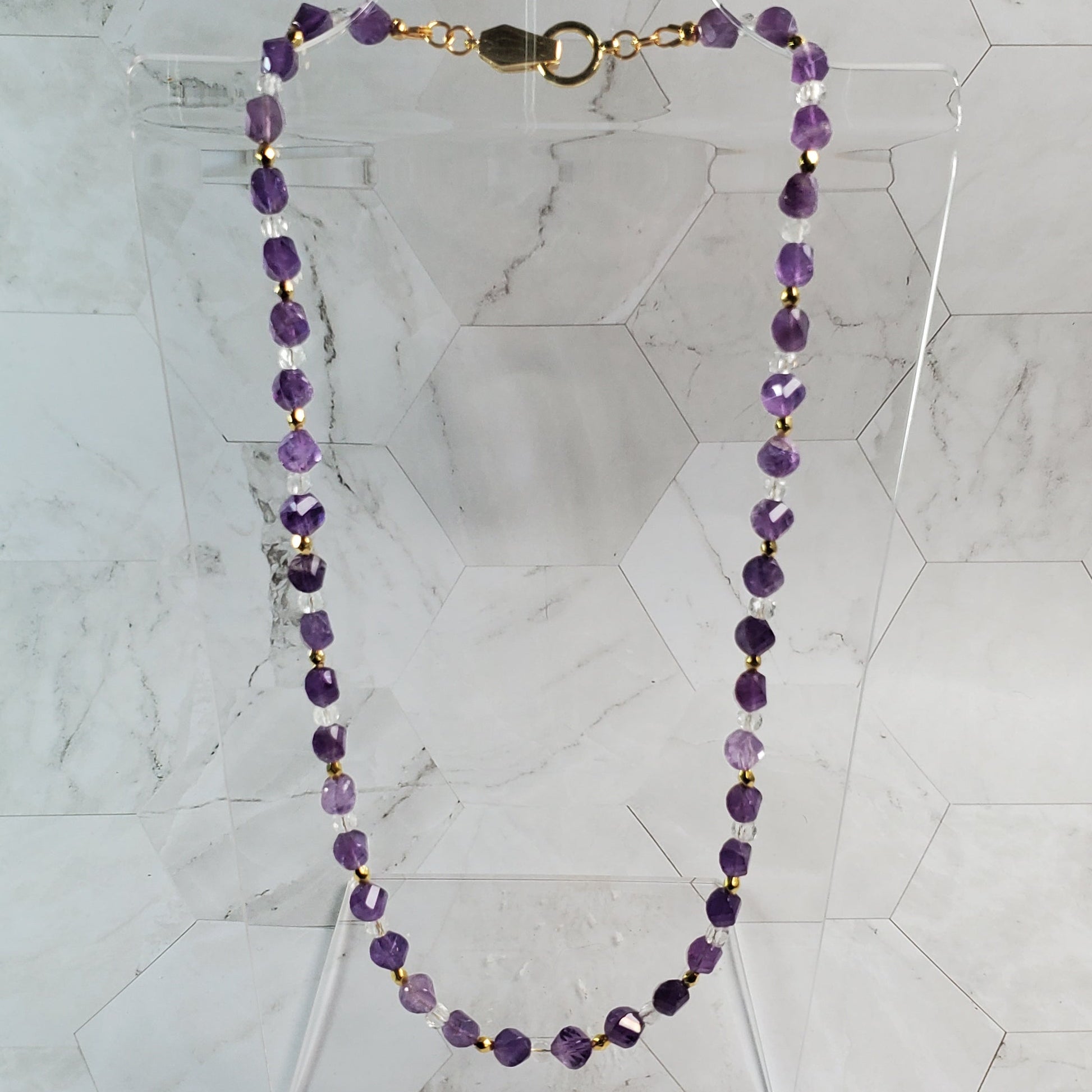 Purple beaded necklace on a marble surface