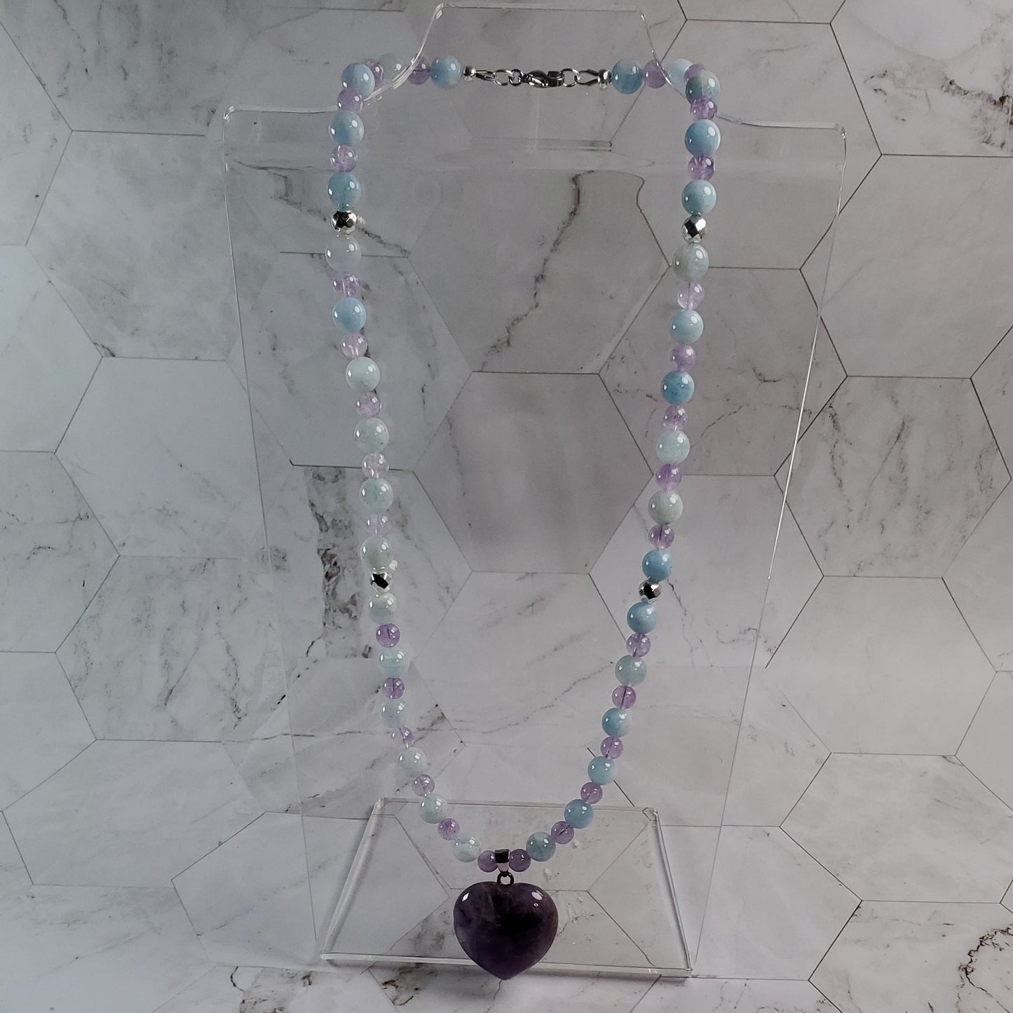 Decorative beaded necklace hanging on a marble wall