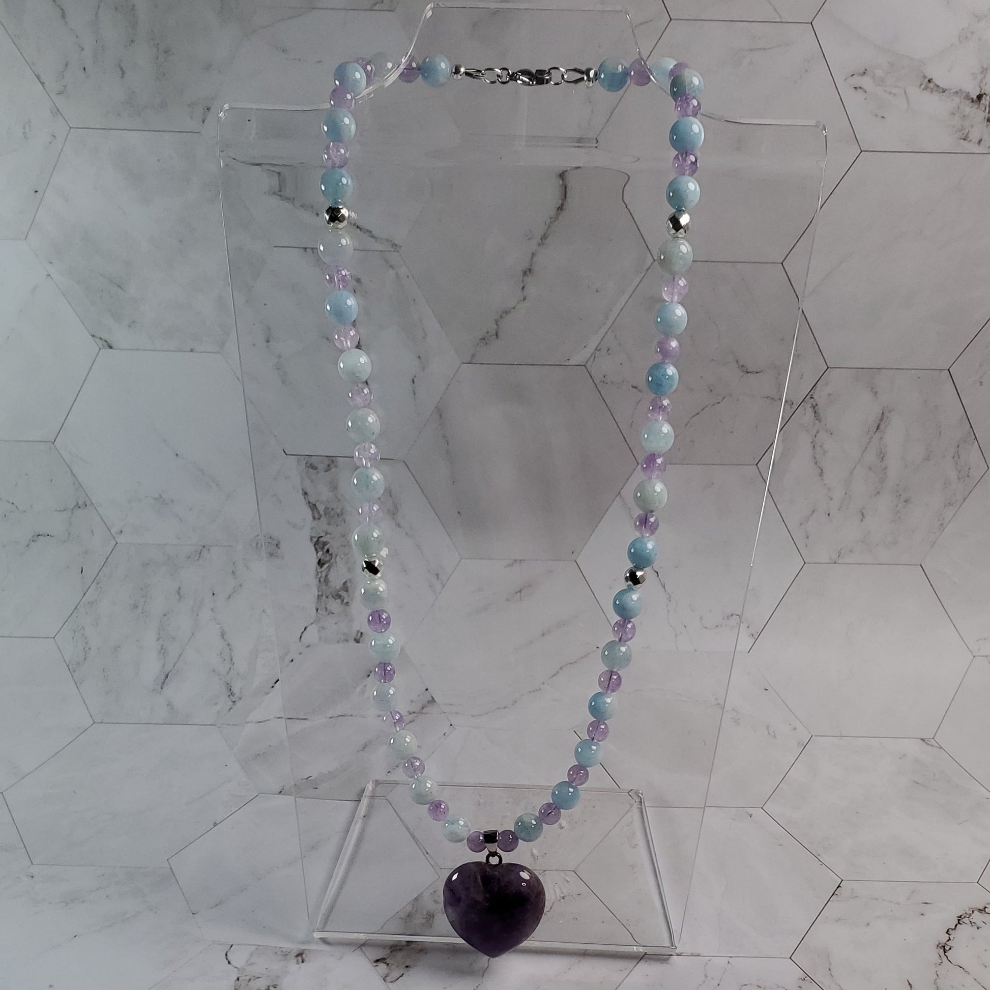 Decorative beaded necklace hanging on a marble wall