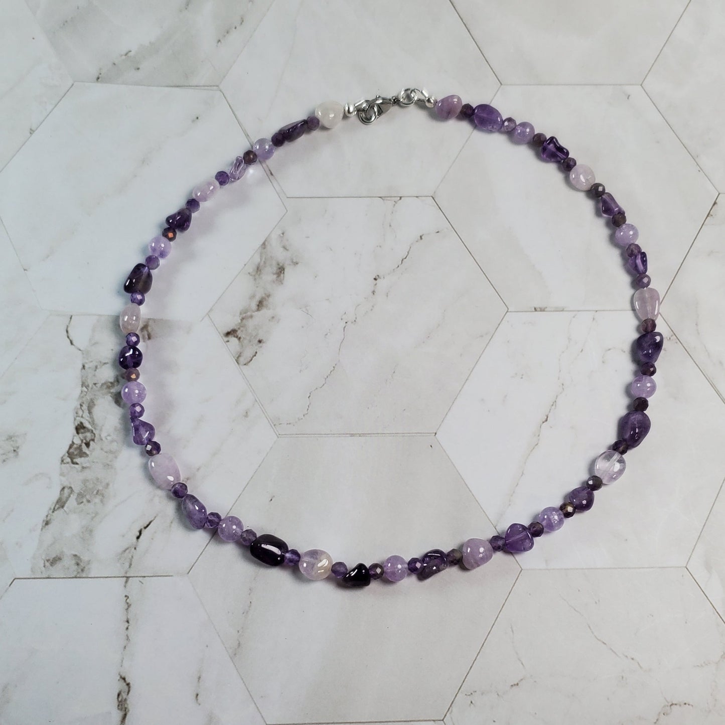 Necklace with purple beads on a marble surface