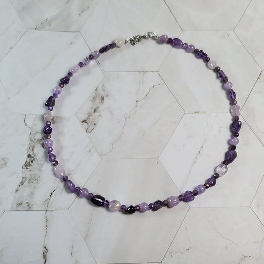 Necklace with purple beads on a marble surface
