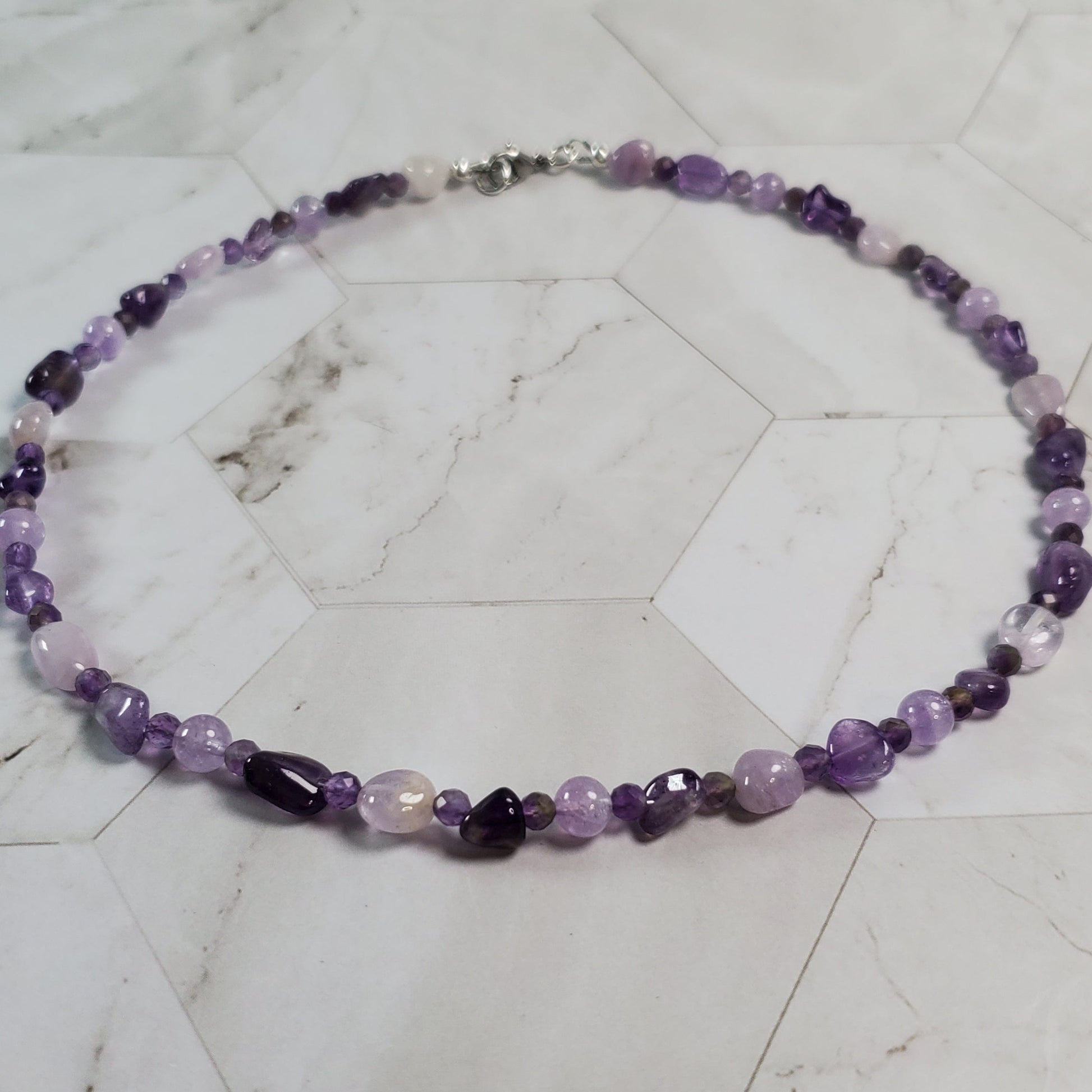 Necklace with purple beads on a marble surface