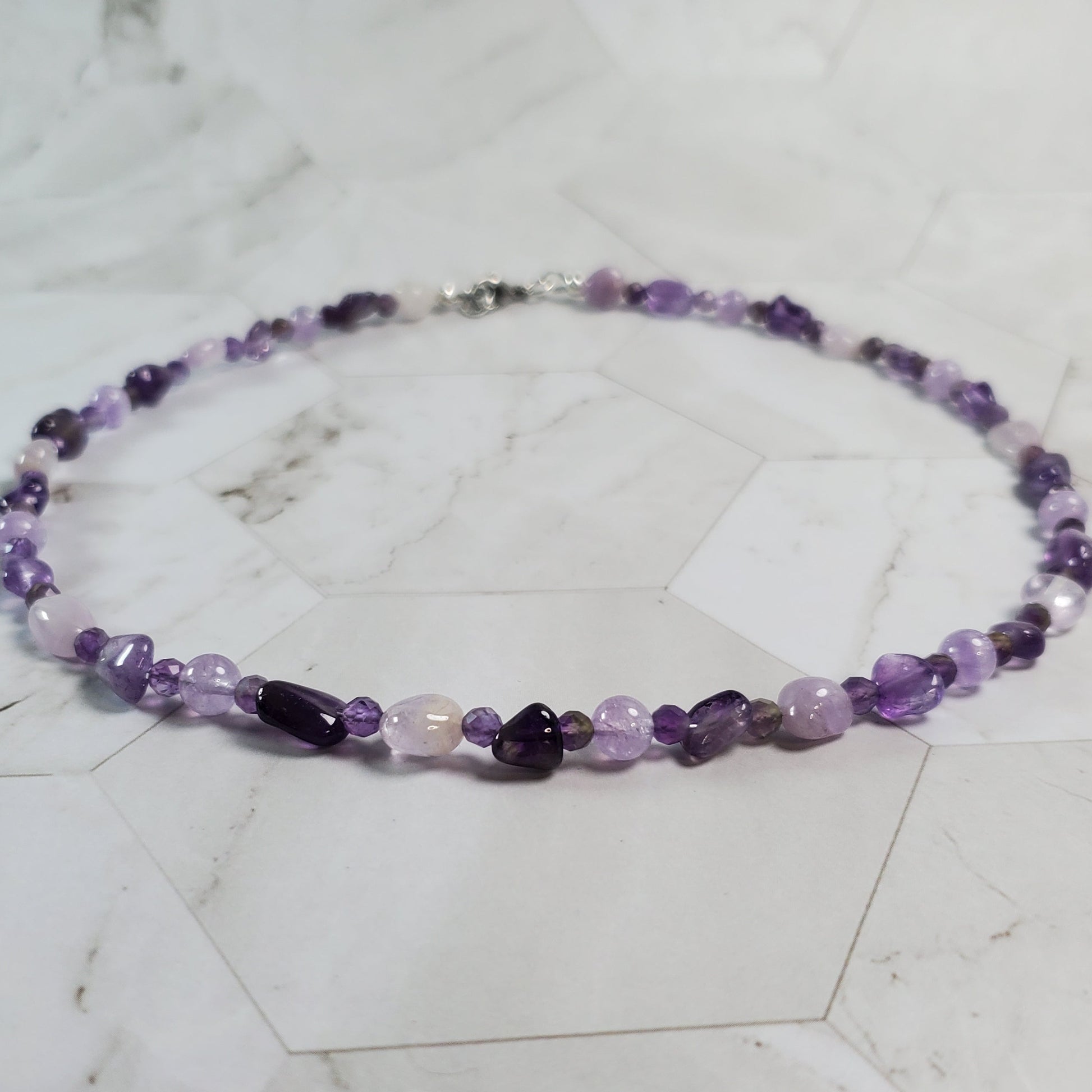 Necklace with purple beads on a marble surface
