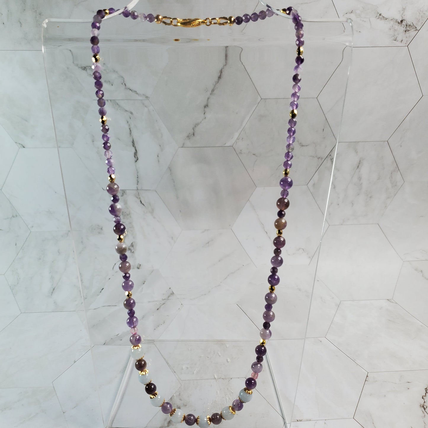 Necklace with purple beads on a marble background