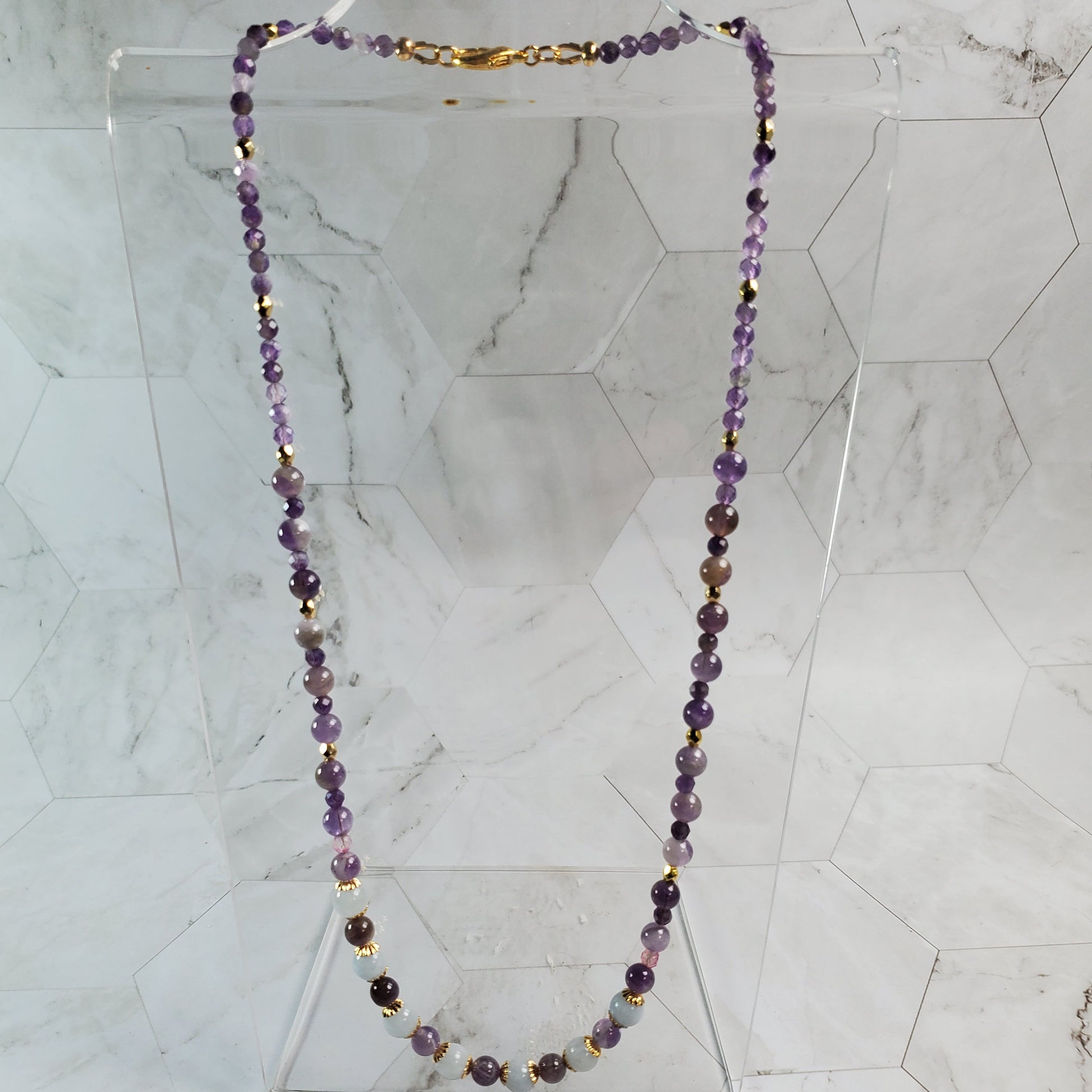 Necklace with purple beads on a marble background