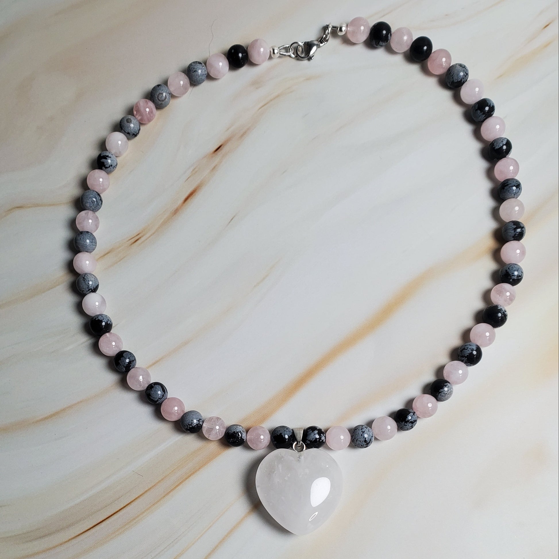 Necklace with heart-shaped pendant on a marble surface