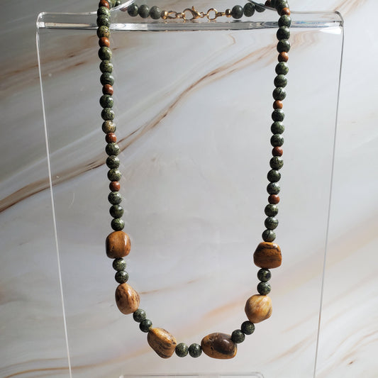 Necklace with wooden beads on a clear stand against a marble background