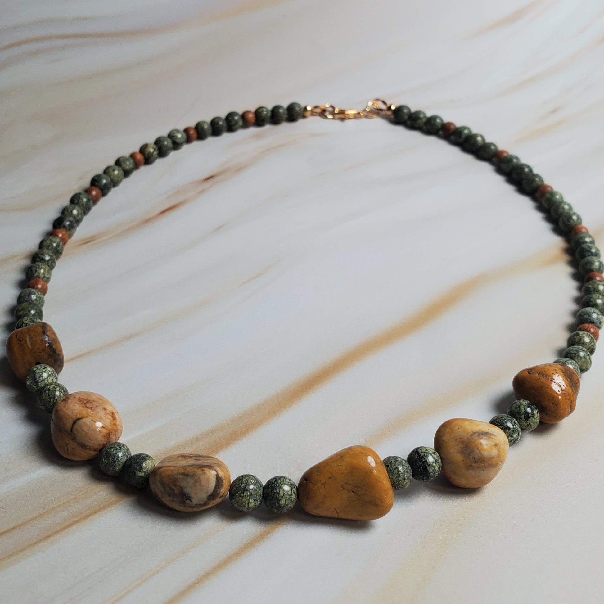 Necklace with natural stone beads on a marble surface