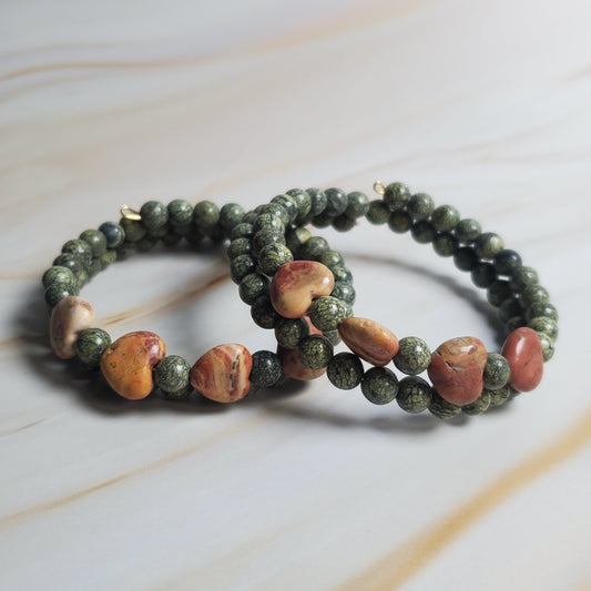Beaded bracelet with green and brown stones on a light marble background