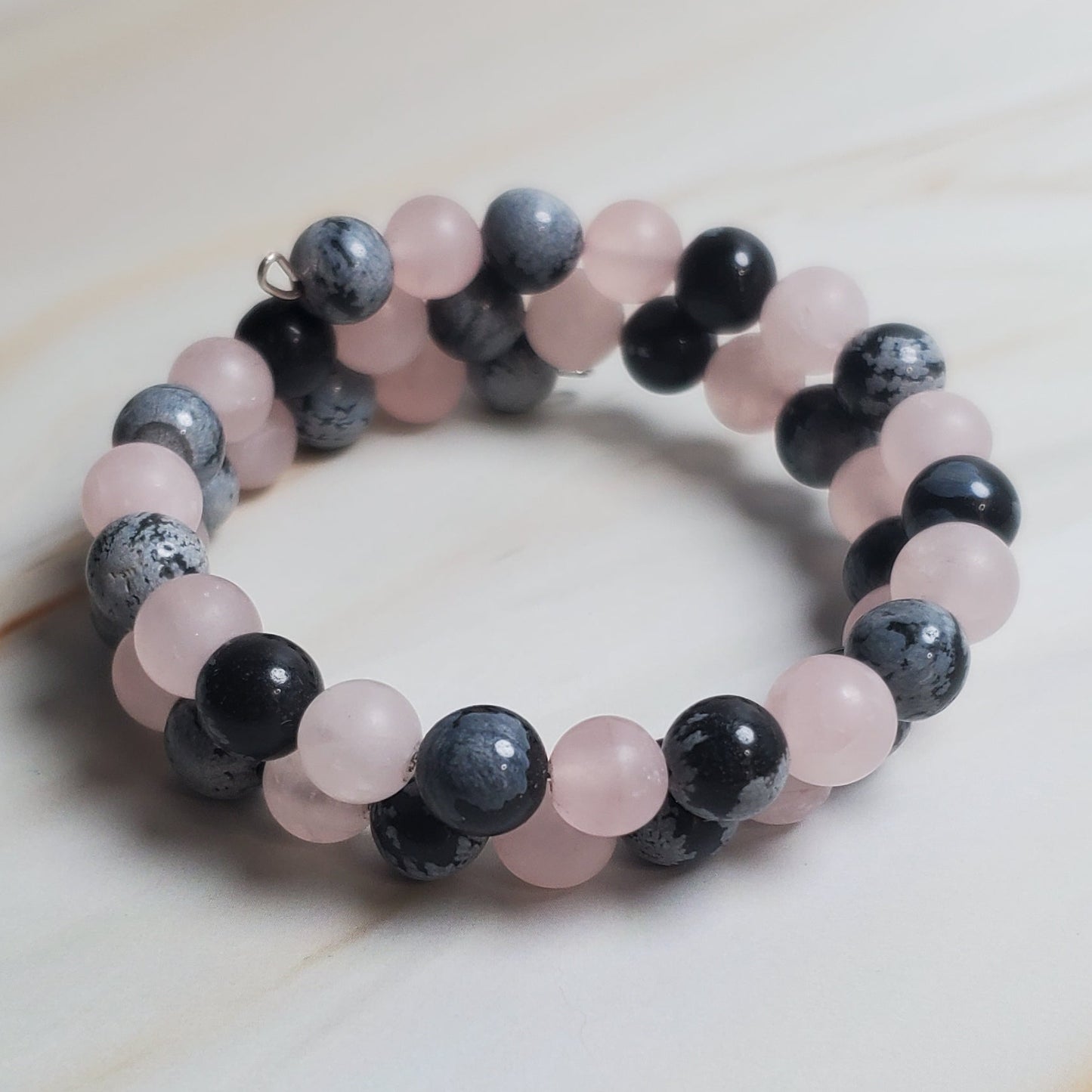 Stacked of beaded bracelet on a light wooden surface