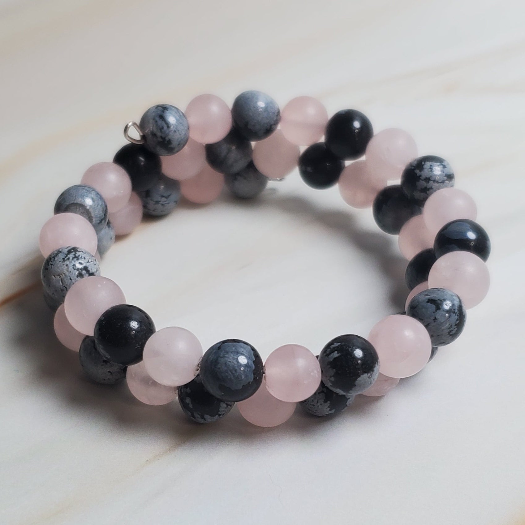 Stacked of beaded bracelet on a light wooden surface