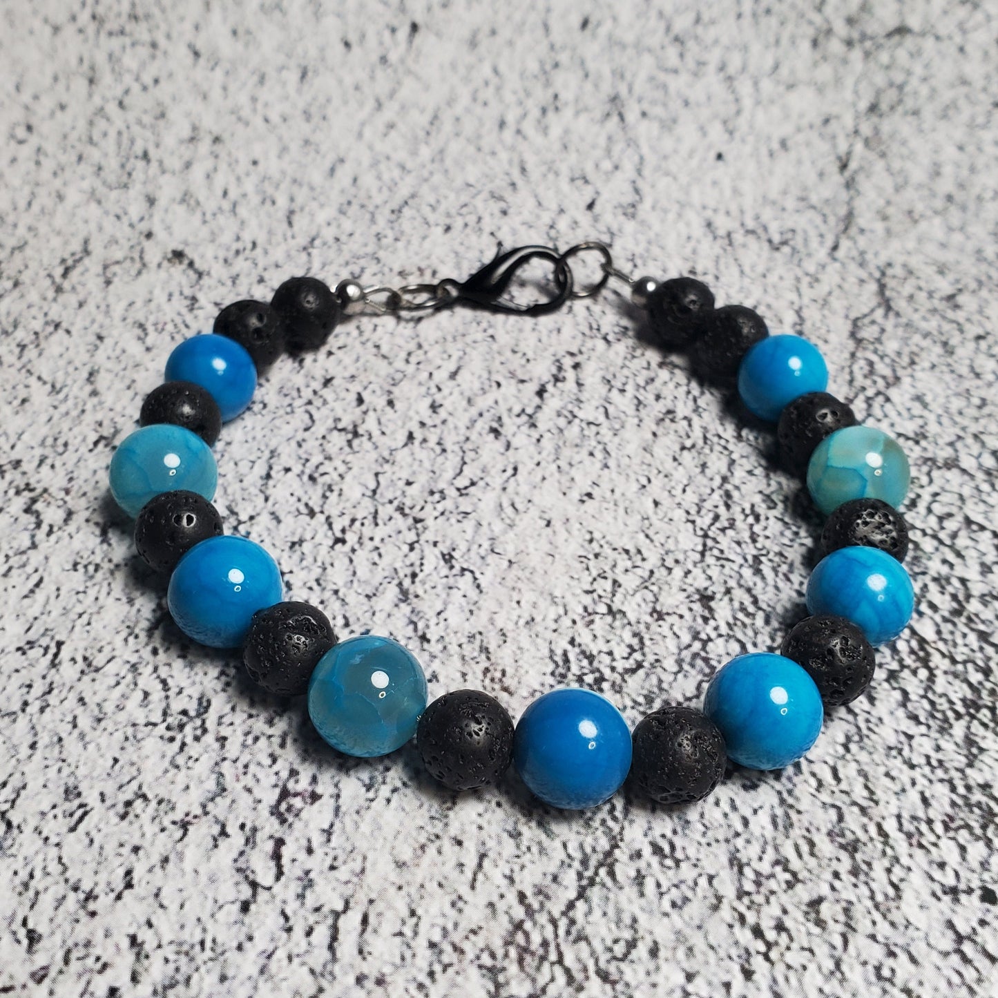 Bracelet with blue and black beads on a textured surface