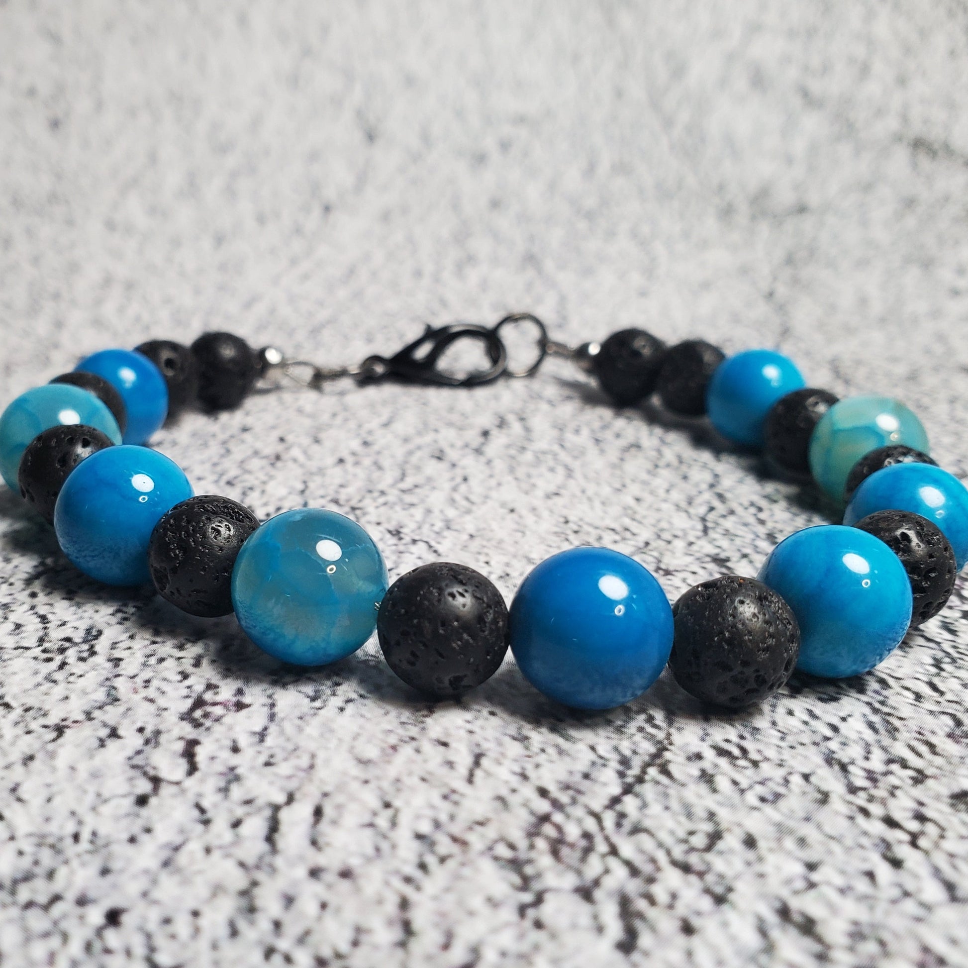 Bracelet with blue and black beads on a textured surface