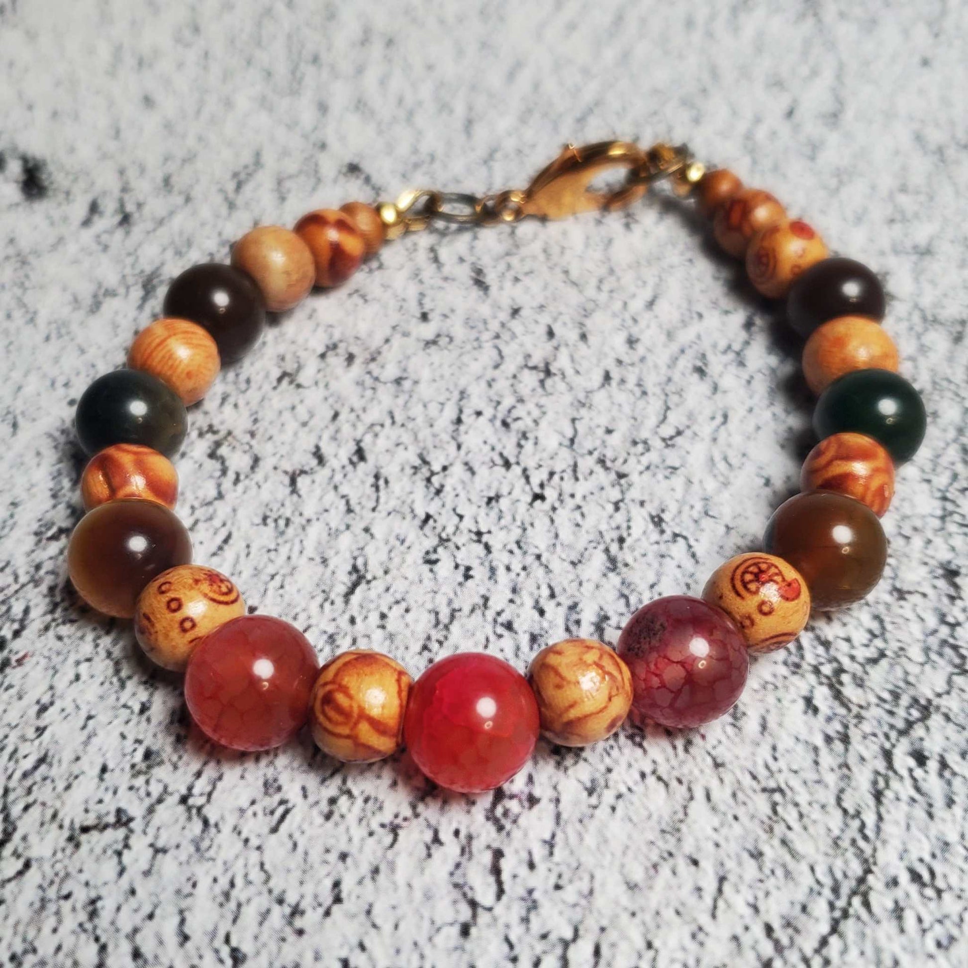 Handcrafted gemstone bracelet featuring Dragon Vein Agate stones and natural wood accents with brass clasp