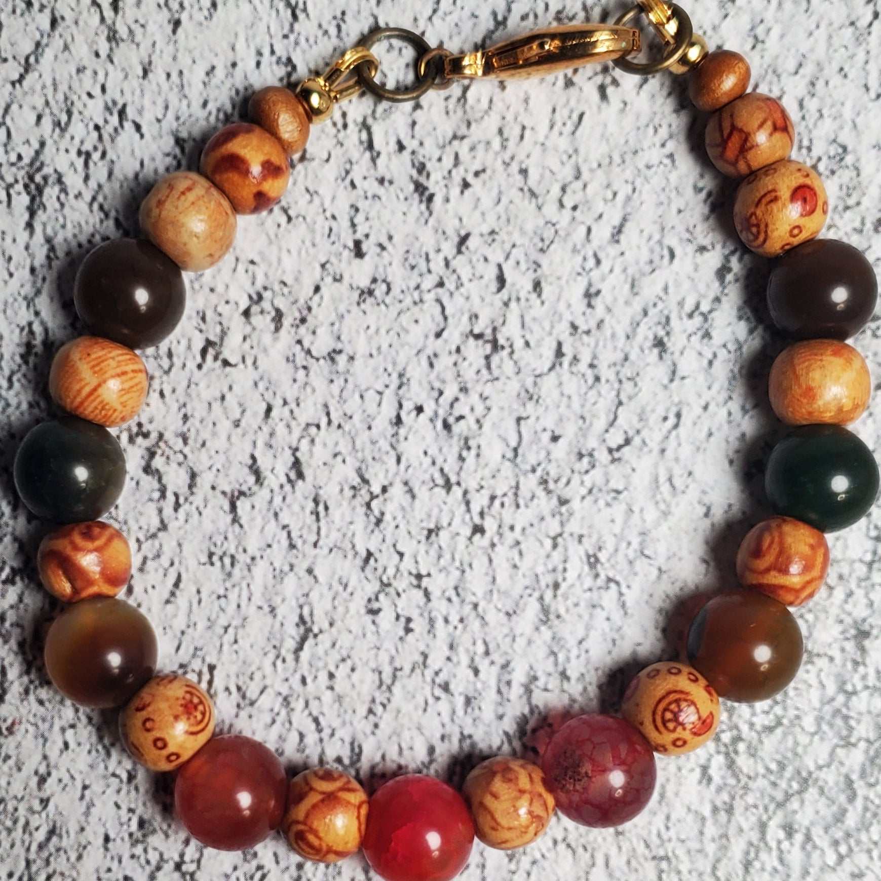 Handcrafted gemstone bracelet featuring Dragon Vein Agate stones and natural wood with brass clasp