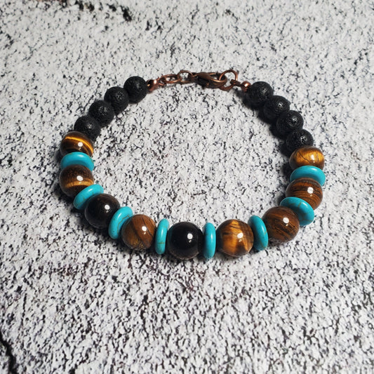Beaded bracelet with black, brown, and turquoise beads on a textured gray surface