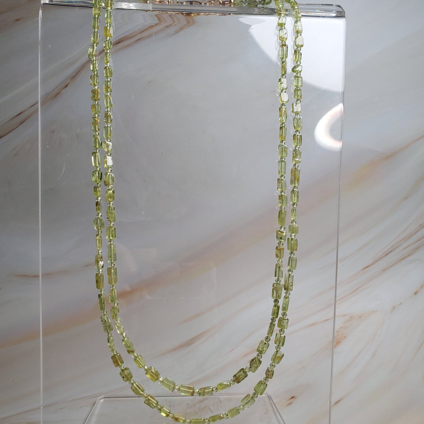 Double-strand gemstone necklace with peridot chips and round beads in vibrant green tones