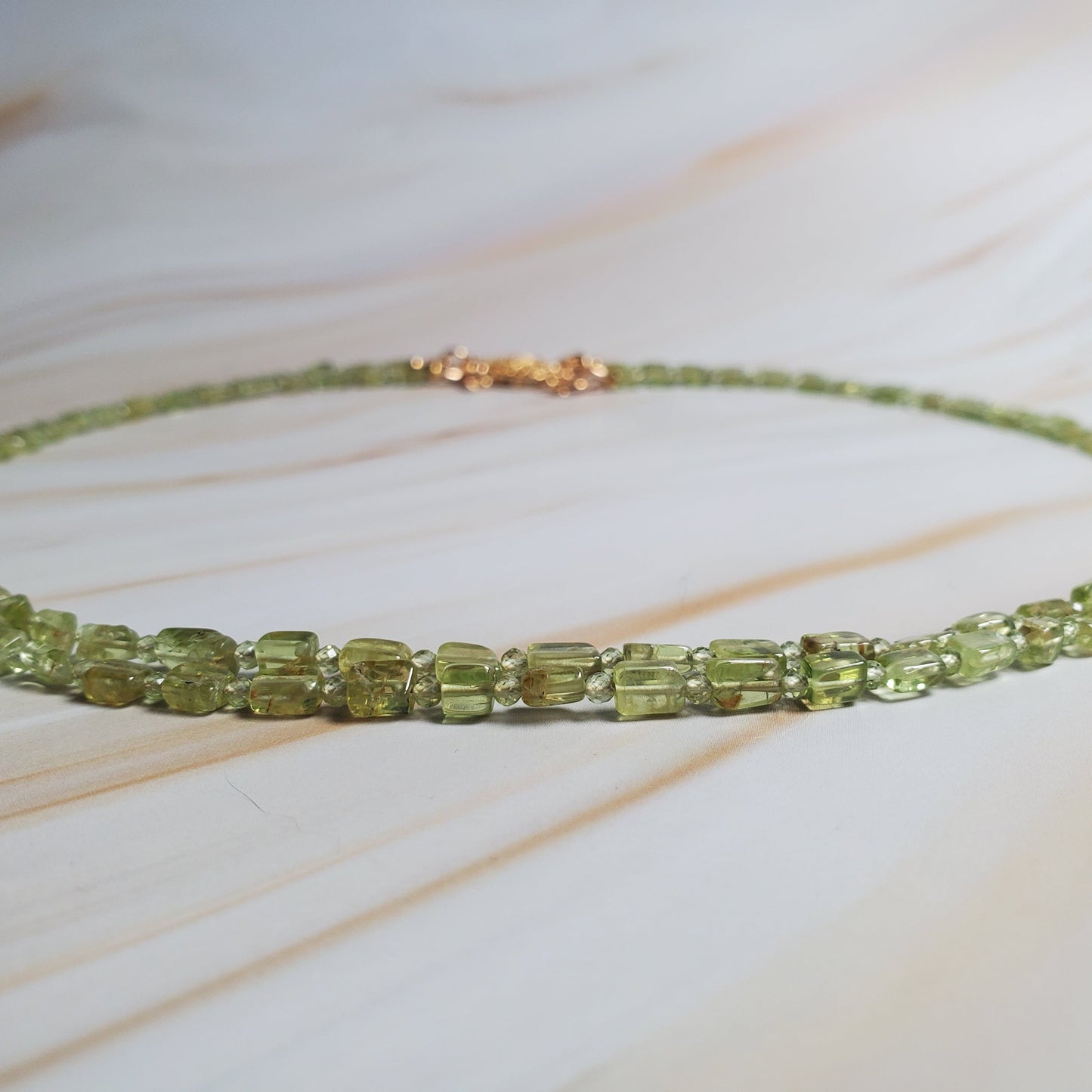 Double-strand gemstone necklace with peridot chips and gold-tone clasp in vibrant green tones