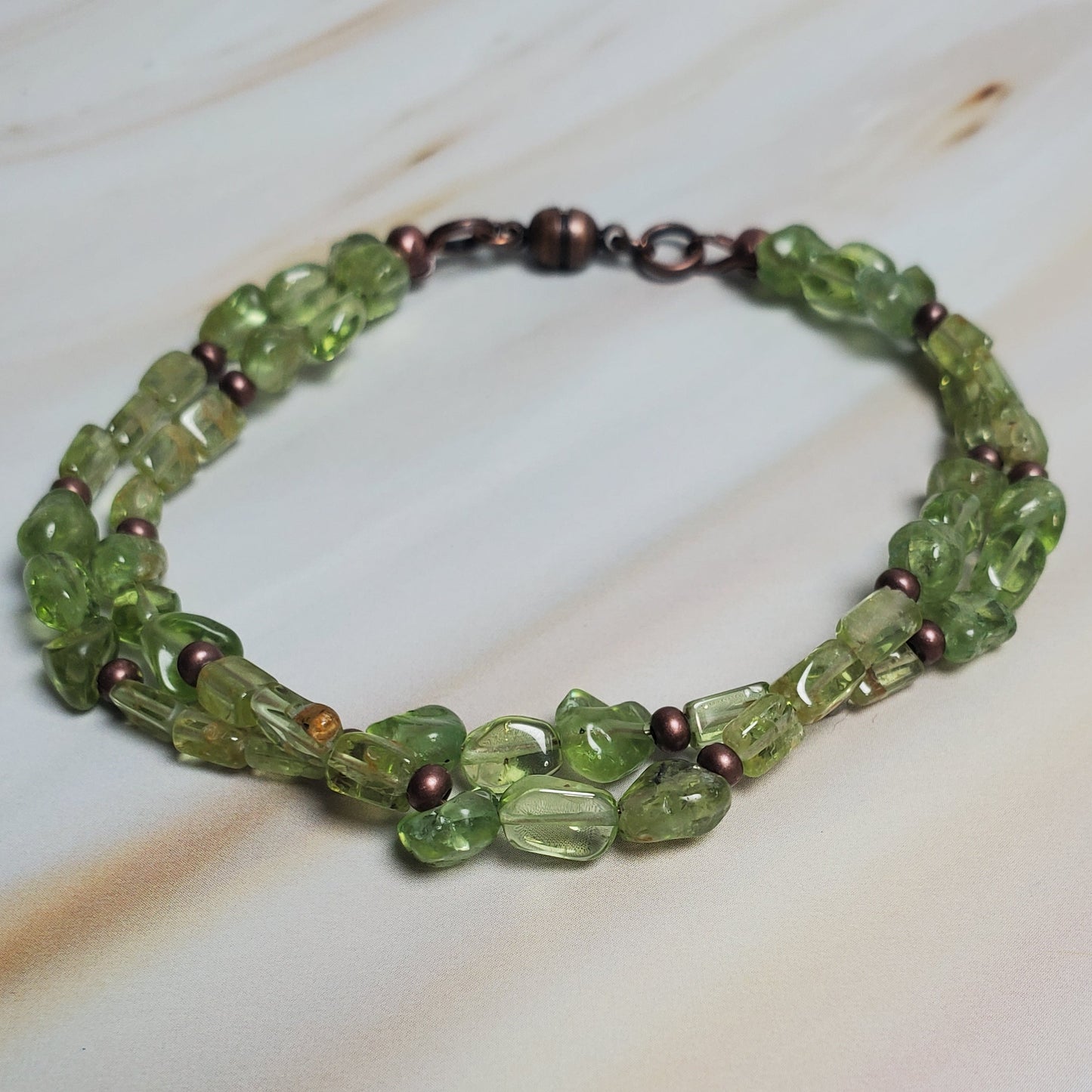 Green beaded bracelet on a light wooden surface