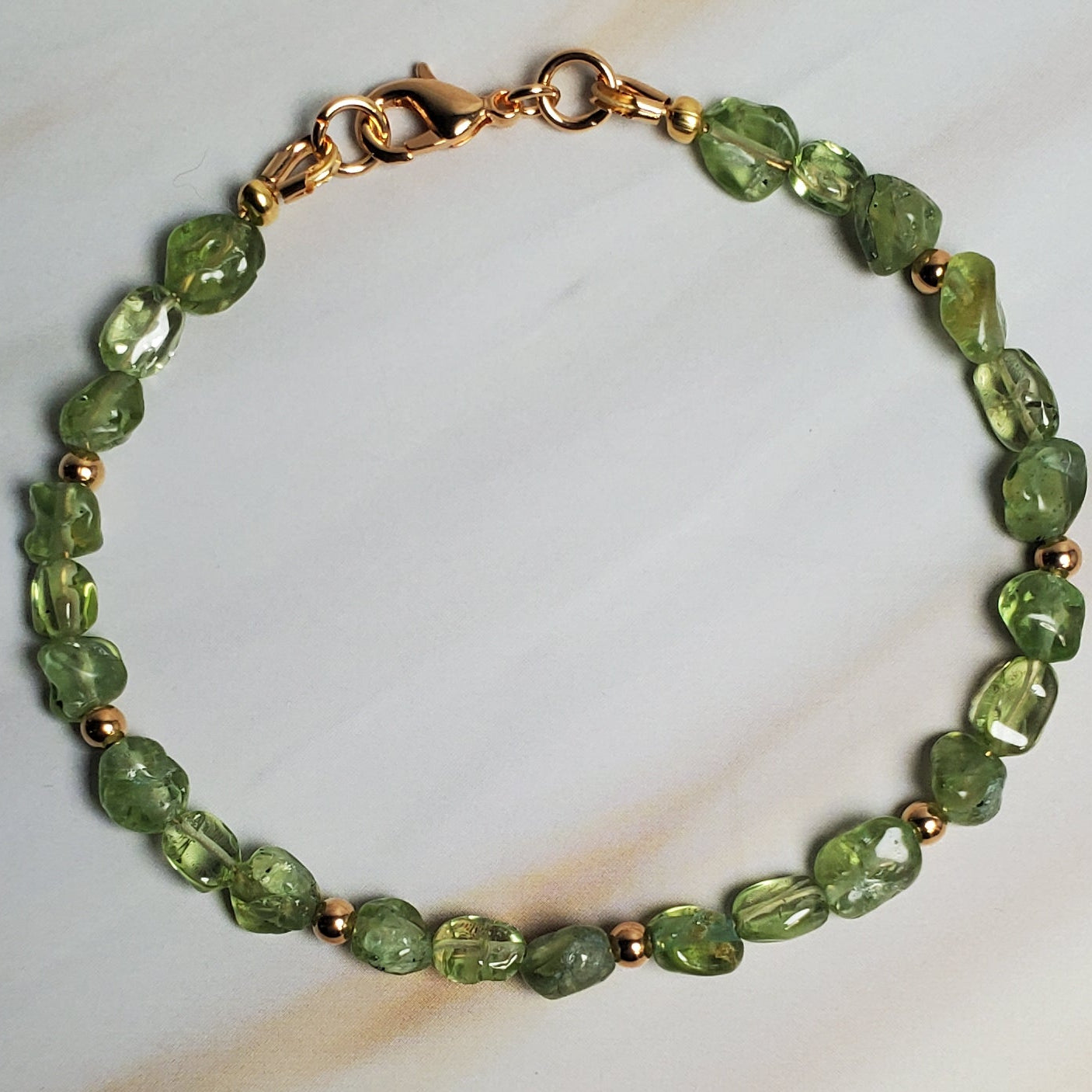 Green beaded bracelet on a marble surface